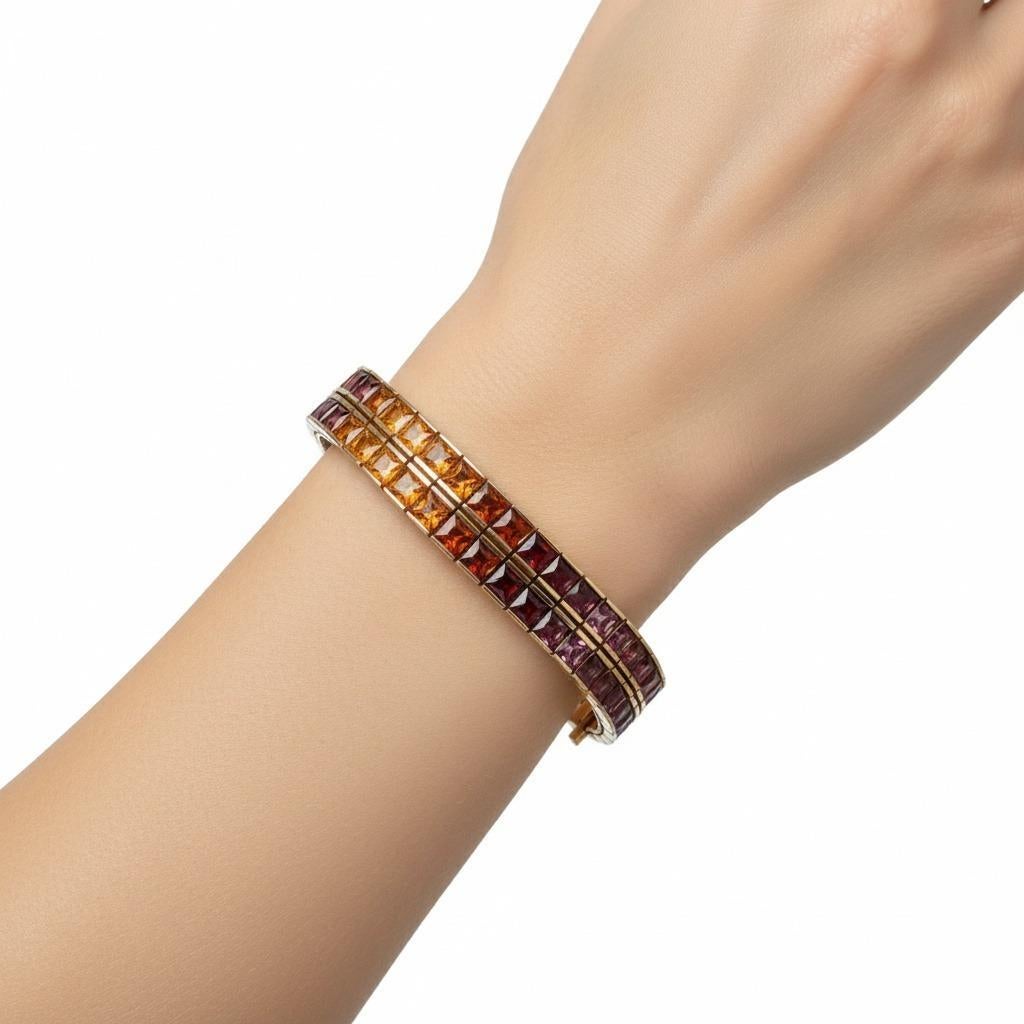 Ce magnifique bracelet arc-en-ciel est le fruit d'un savoir-faire contemporain exceptionnel. Il est réalisé en or jaune 18 carats lustré et rehaussé de deux rangées de 82 pierres fines calibrées, taillées en taille française sophistiquée. La
