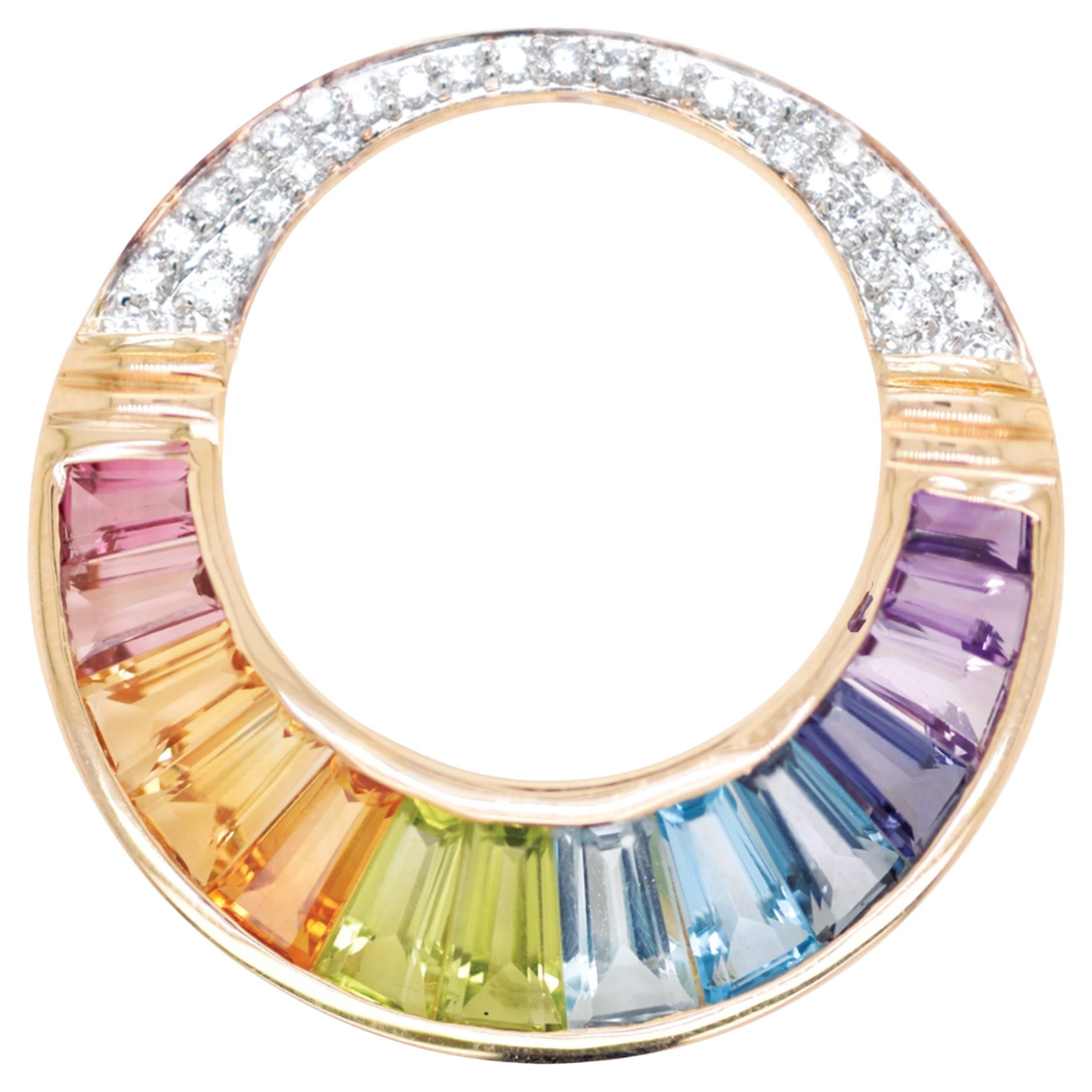 Ciondolo d
oro con iolite arcobaleno, ametista, topazio blu, peridoto, citrino, tormalina rosa.