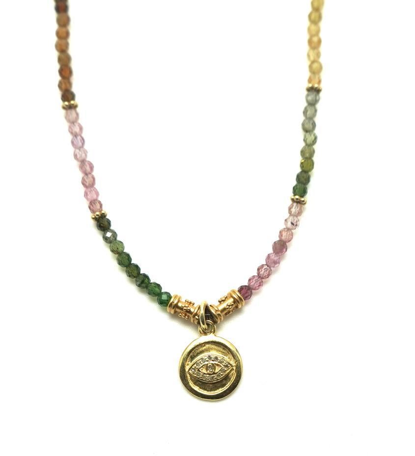 Behind the Jewelry
The Kaleidoscope Eye necklace is adorned with a pave diamond evil eye pendant set in 14K gold.  The pendant is adorned with rainbow tourmaline.  The symbolic eye allows one to see the magical colors that lie through the peep hole