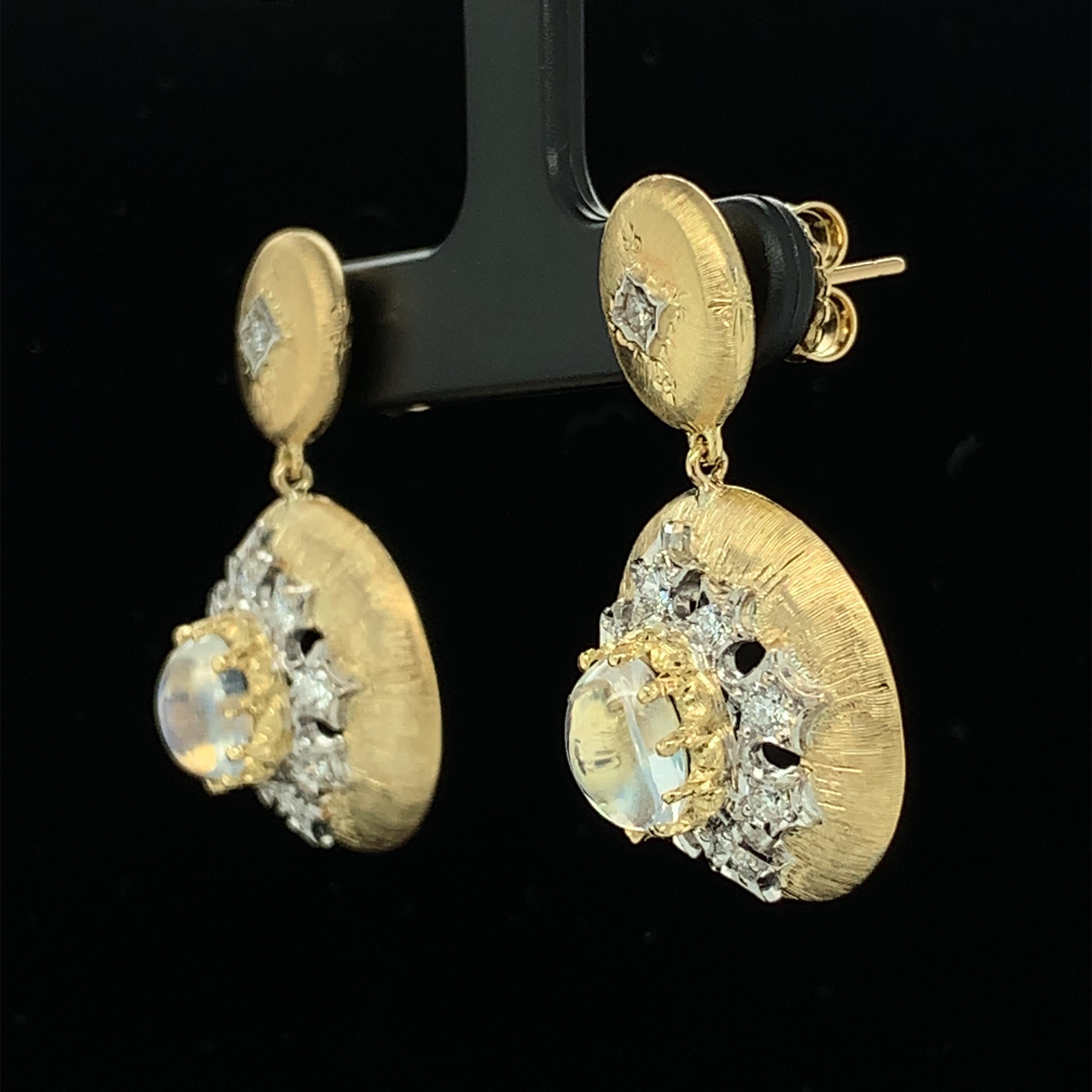 These Florentine style earrings are elegance personified! They feature two high-domed oval rainbow moonstones that exhibit highly-prized, colorful adularescence, surrounded by individually set, sparkly round brilliant cut diamonds. Handmade in 18k