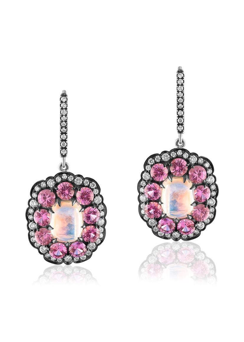 “ Moon In The Pink” 18 K White Gold Earrings with Rainbow Moonstone Centers Surrounded by Hot Pink Sapphires and Accented By Diamonds.
Rainbow Moonstones Are Eye Clean and Displaying Blue, Green, Yellow but have A Red Shen. 
Rainbow Moonstones 5.34