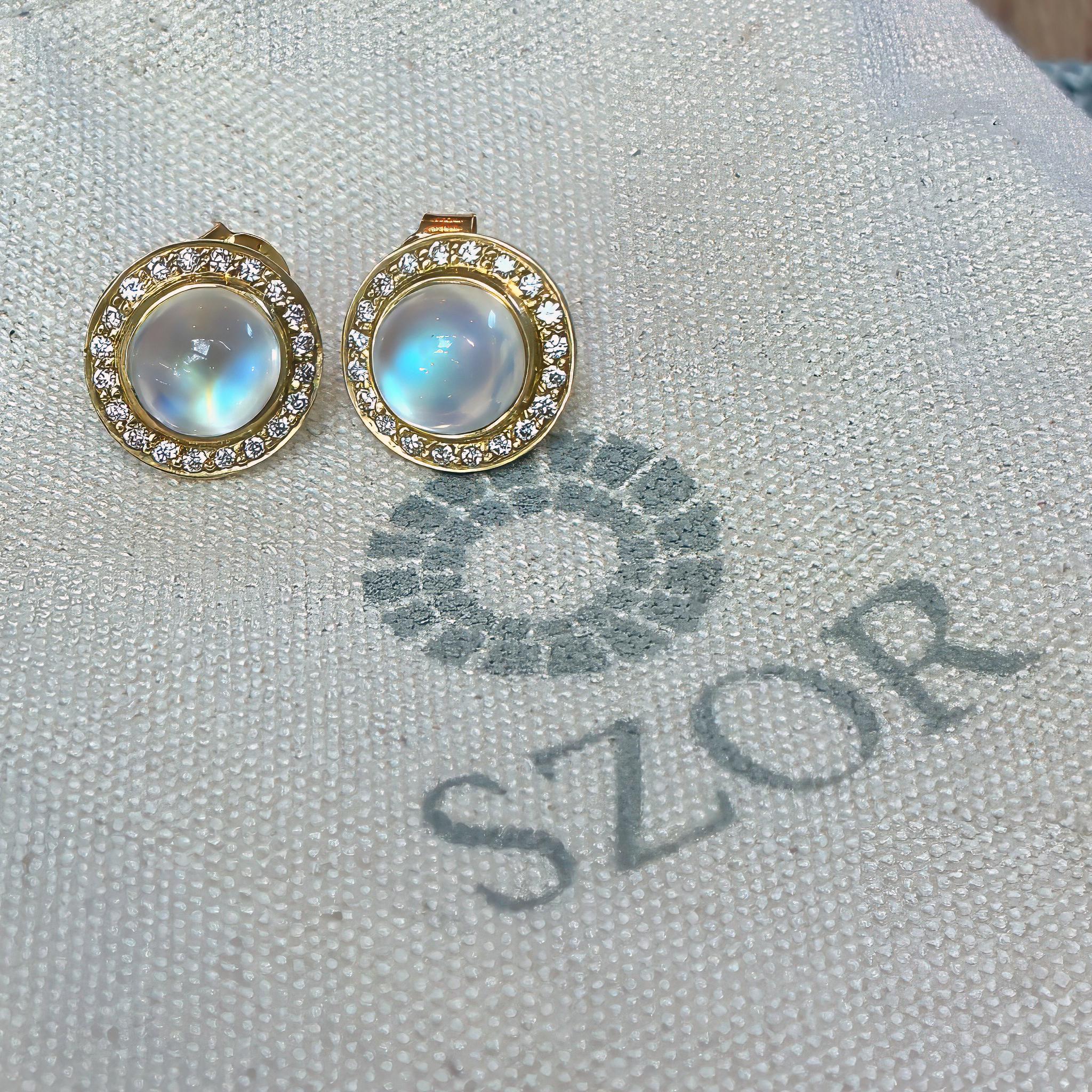 One of a Kind Button Stud Earrings handmade in matte-finished 18k yellow gold by jewelry artist Tej Kothari showcasing a gorgeous matched pair of vibrant rainbow moonstone cabochons surrounded by round white diamonds totaling 0.25 carats in weight.