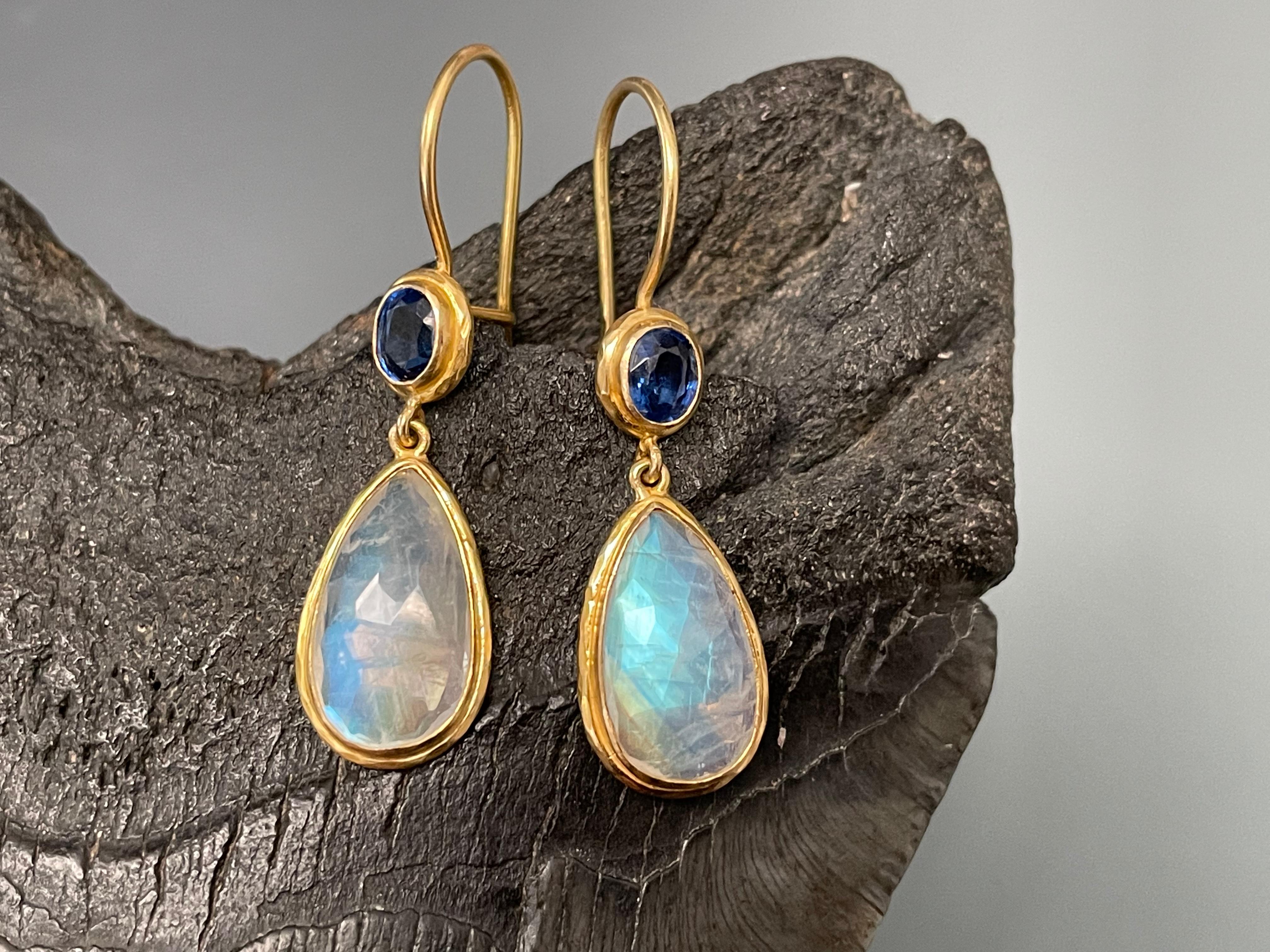 Handset 6 Carats of rose cut rainbow moonstone 8 x14 mm elegant pear shaped stones dangle below safety clasp earwires with 3x5mm faceted Kyanite ovals at the bottom.
Set into hammered matt-finish bezels.  Beautiful complementary colors !
