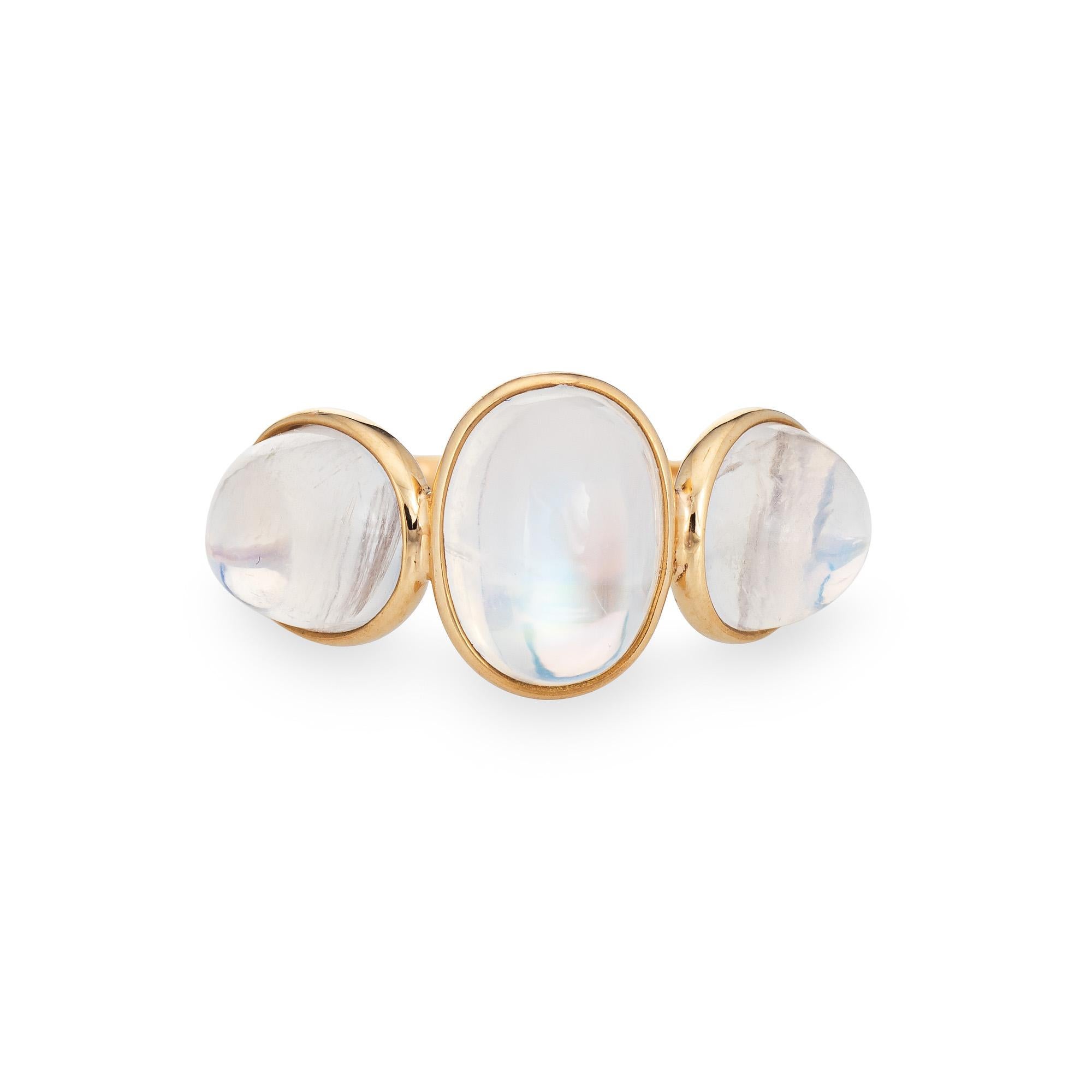 Stylish contemporary three stone rainbow moonstone ring crafted in 18 karat yellow gold. 

Cabochon cut moonstones total an estimated 7.76 carats. The moonstones are in good condition and free of cracks or chips.  

Three high dome cabochon cut