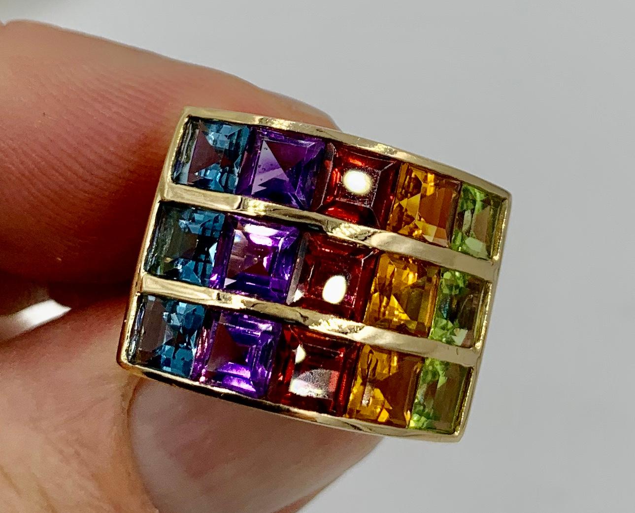 A spectacular Retro Ring set with a rainbow of gorgeous gems - Topaz, Amethyst, Garnet, Citrine and Peridot.  The gems are Square Cut and are channel set in 14 Karat Yellow Gold.  The gems are of the highest quality and the rainbow of colored jewels