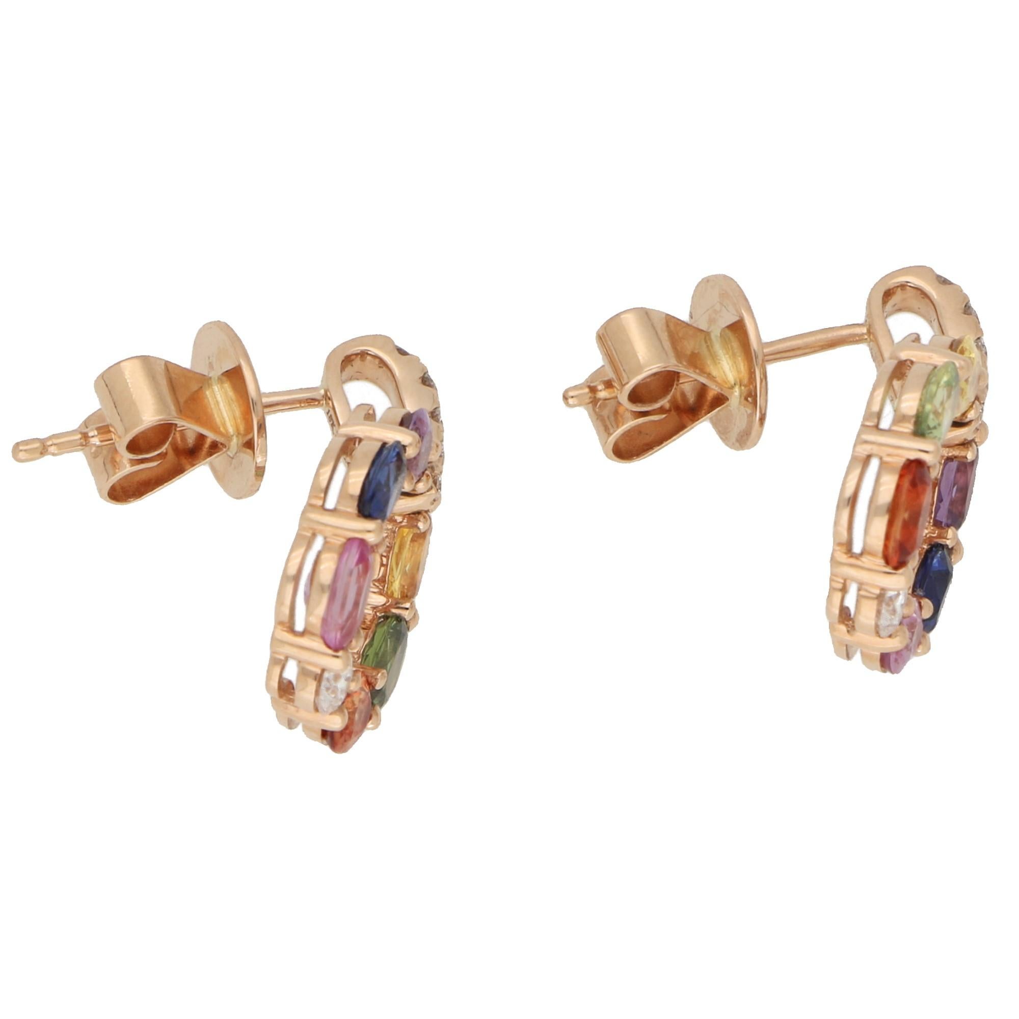 A beautiful pair of rainbow sapphire hoop earrings set in 18k rose gold.

The earrings are predominantly set with six oval cut rainbow sapphires set in a perfect hoop shape. This hoop is secured on a pave set diamond drop and is articulated so that