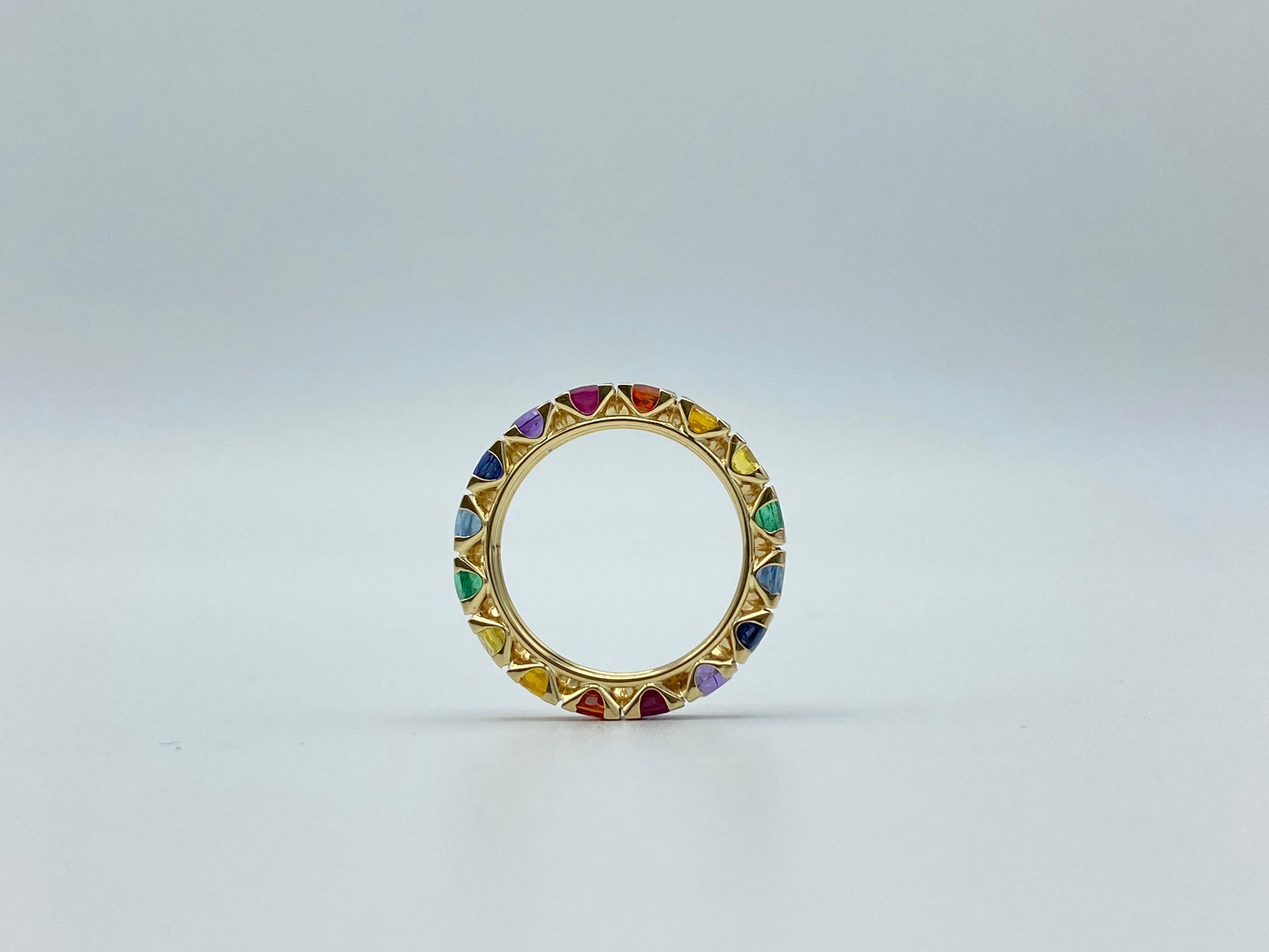 This multicolor eternity ring is set from 16 stones. It has yellow, dark yellow, orange, and blue sapphires; emeralds, rubies, aquamarine and amethyst. 
I put the stones in color gradation to get a rainbow surrounding the finger.

The yellow gold is