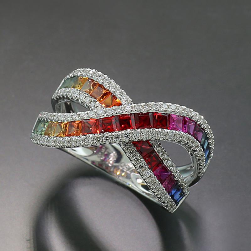 A true eye catcher: Ring with two crossed bands as the ring head, set with 31 sapphires total approx. 2.16 carats, in the color line of a rainbow of green, yellow, orange, red, pink and blue,  princess cut, in open channel setting. The sapphire