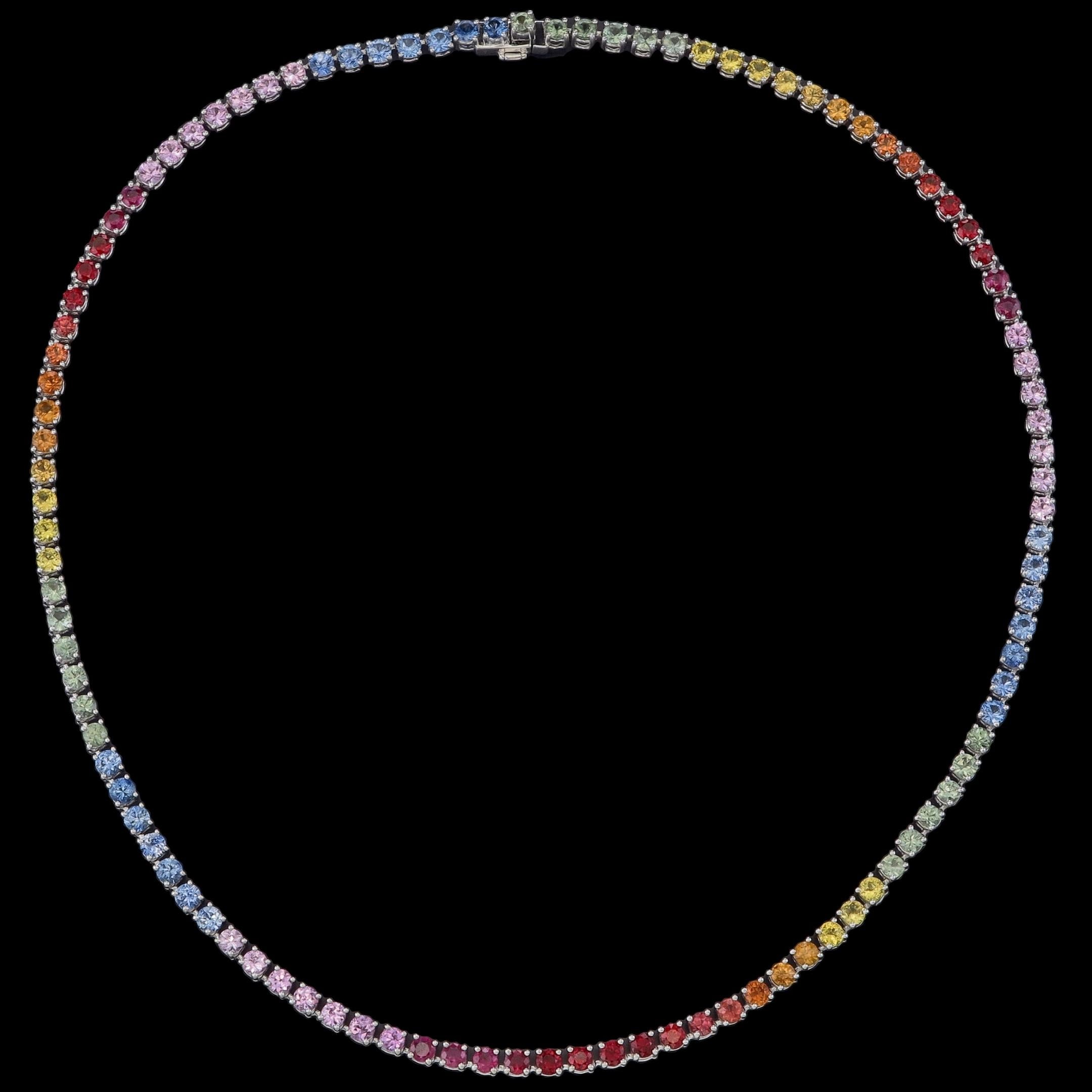 Illumina il tuo stile con questa collana tennis con zaffiri arcobaleno, una celebrazione abbagliante di colore e maestria. Realizzata a mano in oro bianco 18 carati, la collana presenta 14,4 carati di zaffiri taglio brillante disposti in