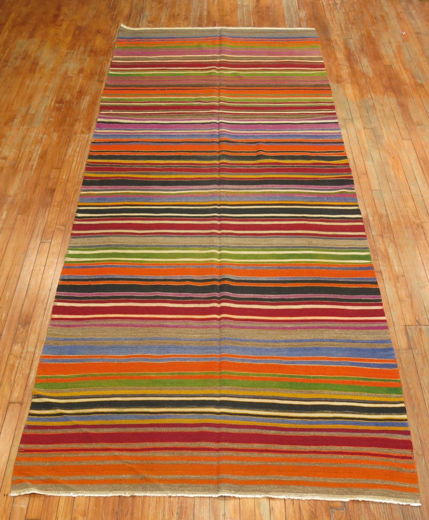Mid-20th century hand knotted one of a kind Turkish Kilim with a brightly colored striped design.

Measures: 5'3