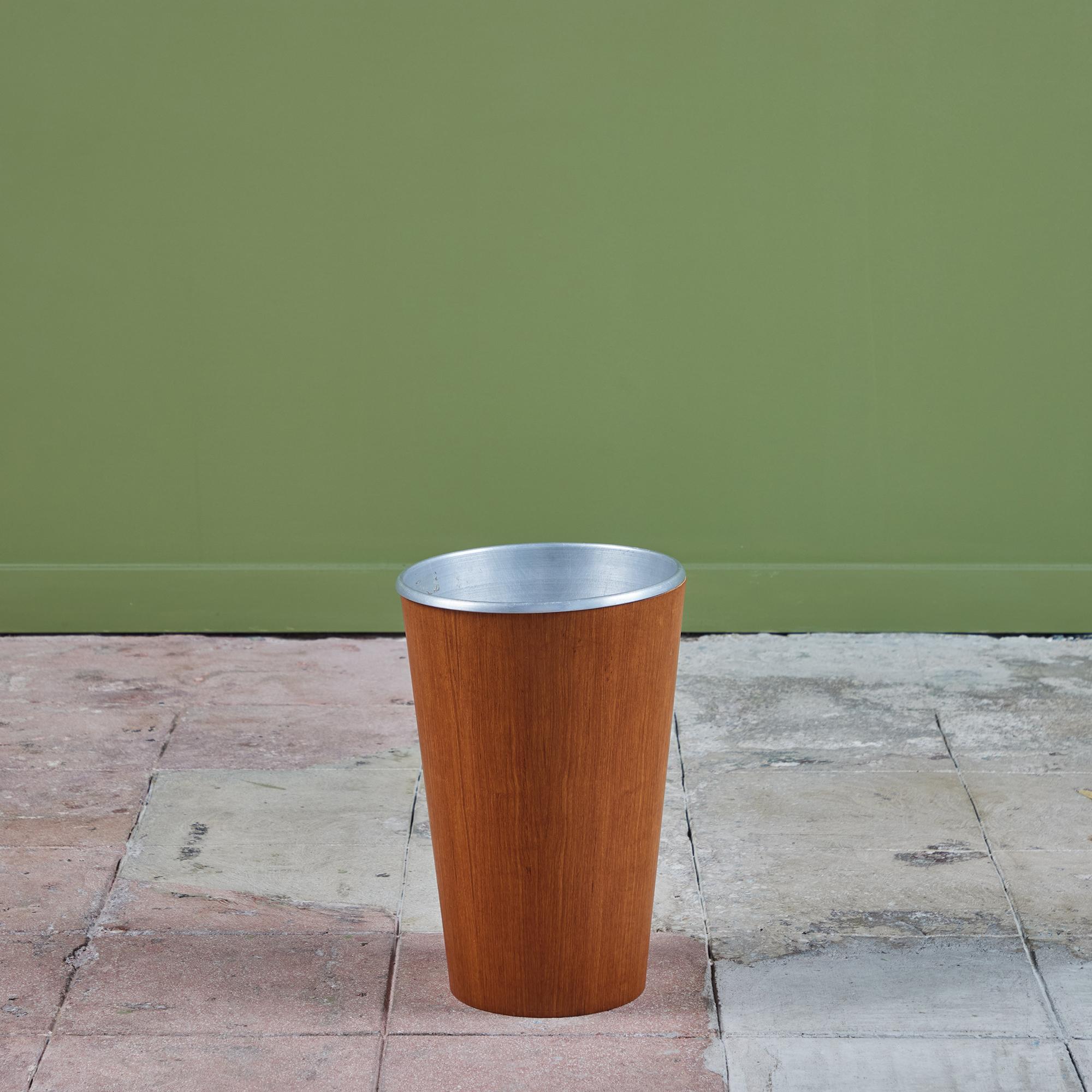 Made in Sweden, this teak wastebasket for Rainbow c.1960s, features a thin circular bent plywood body that tapers towards to the bottom of the bin. The inside of the bin is lined with a removable aluminum insert.

Dimensions
﻿﻿11
