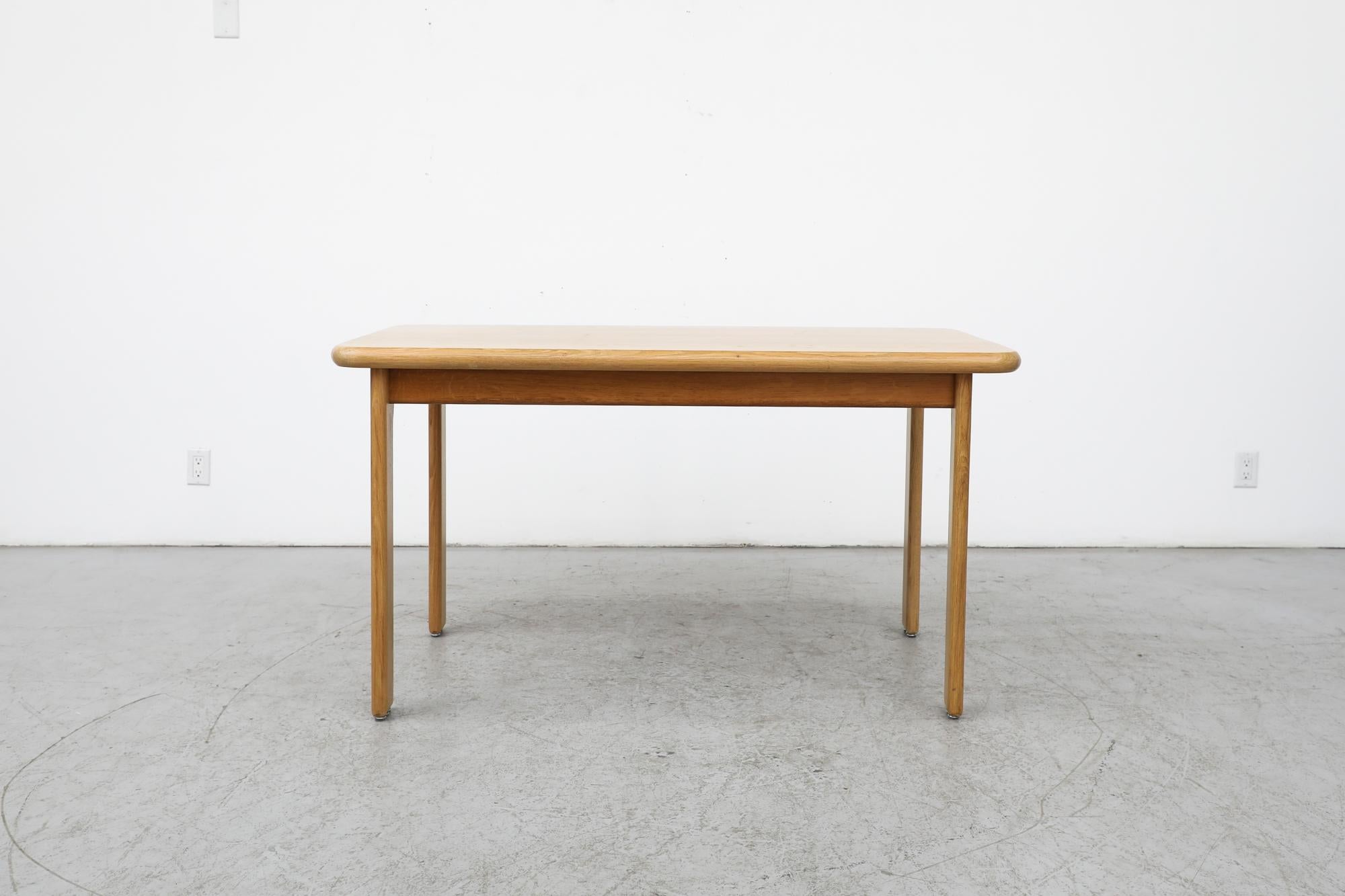 Mid-century, Rainer Daumiller style solid oak dining table with rounded, organic, soft-edged legs and rectangle top. Table is in original condition with some visible wear consistent with its age and use. A lovely example of light and open design