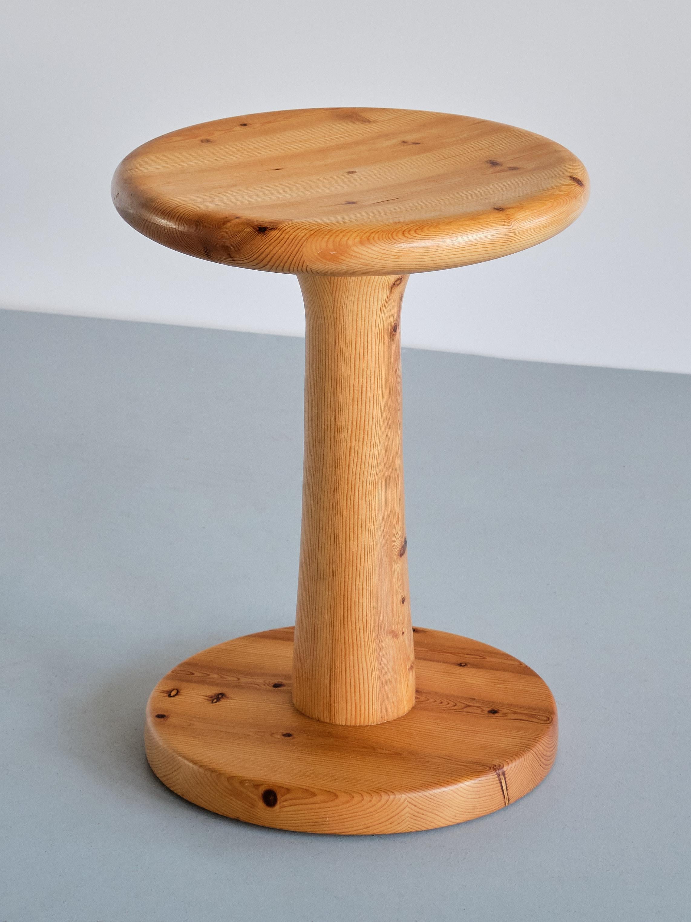 This striking stool was designed by Rainer Daumiller and produced by Hirtshals Savværk in Denmark, 1970s. The design is marked by the circular base and seat and the slightly tapered column. The stool is made of solid pine wood with a visually