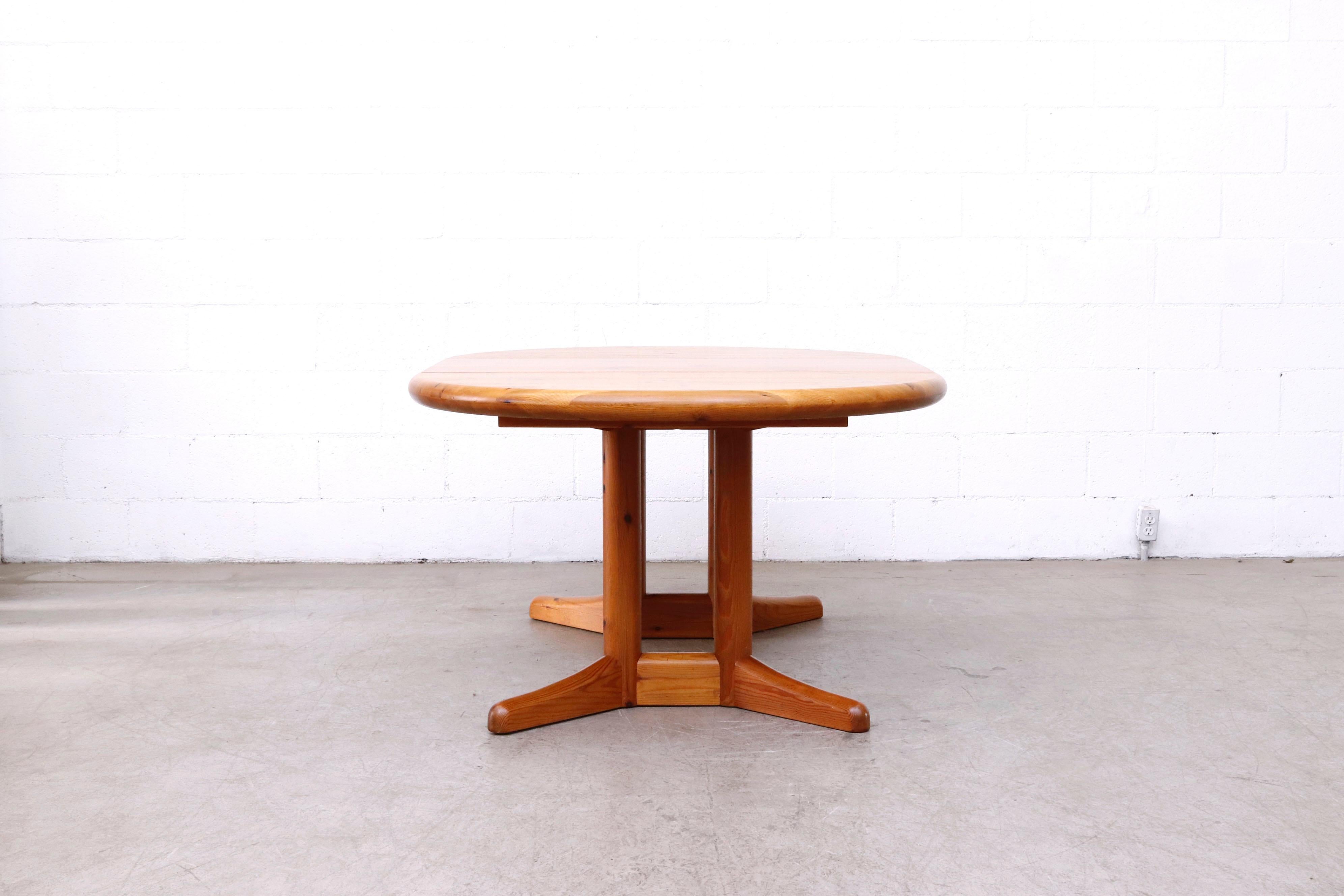 Rainer Daumiller style round-to-oval pine dining table with extension leaf. Extends to 67.25