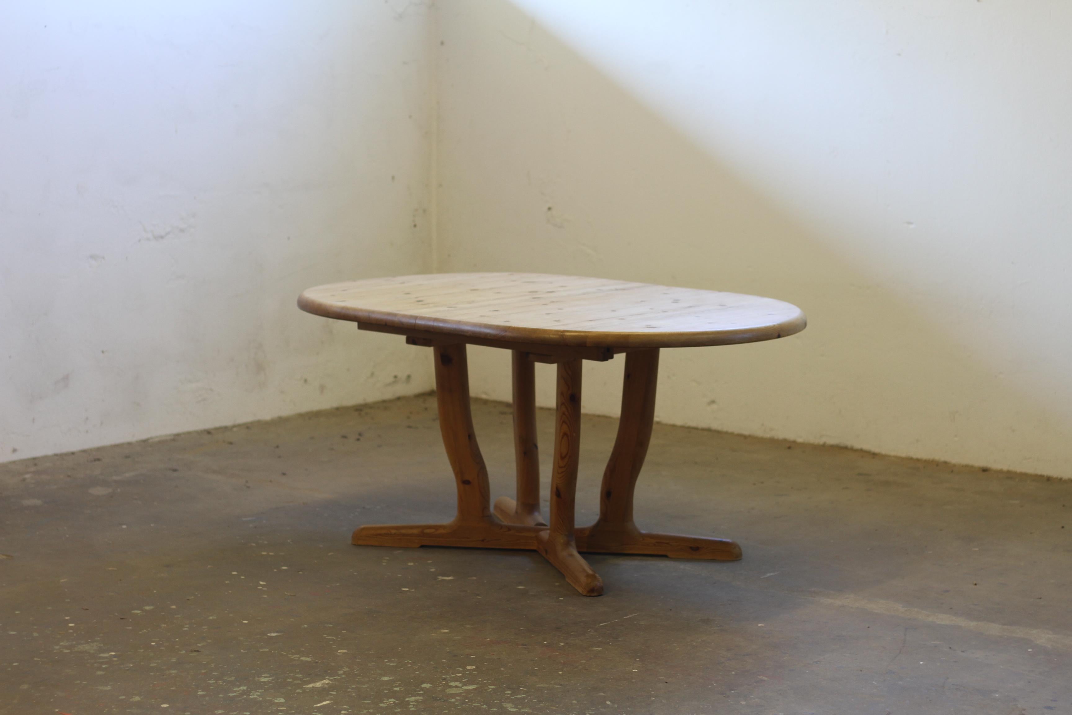 Large, beautiful solid pine dining table with extension. The table is crafted from thick pine wood, organically shaped with soft curves and rounded edges. It has been lightly oiled and left raw in its expression — we deliberately chose not to sand