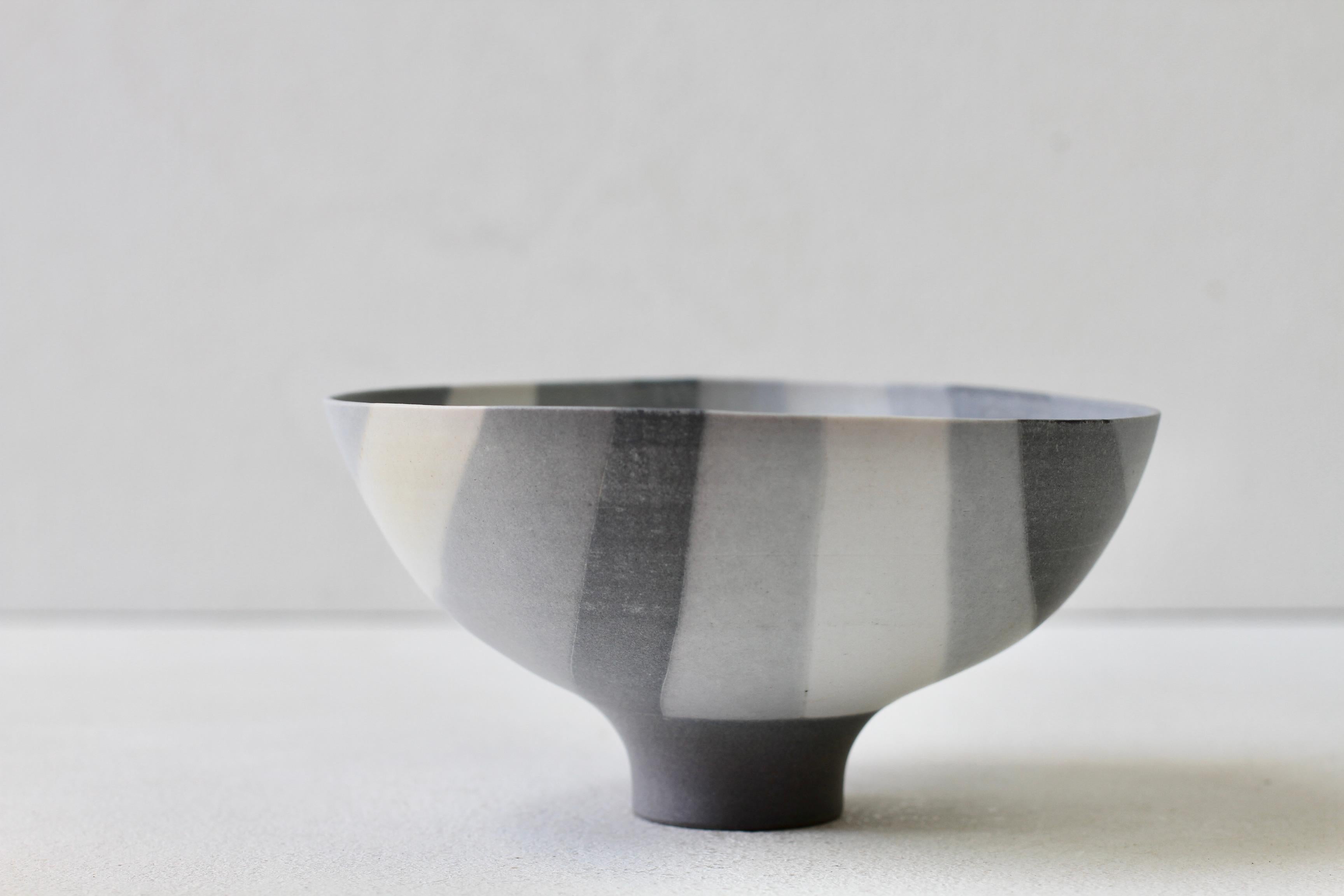 We are very proud to be able to present and offer this exceptional, stunning shades of grey and white striped bowl by German ceramic artist Rainer Doss (1941-2007). This piece is from 1981 and was formed using the Nerikomi technique (練り込み) - is a