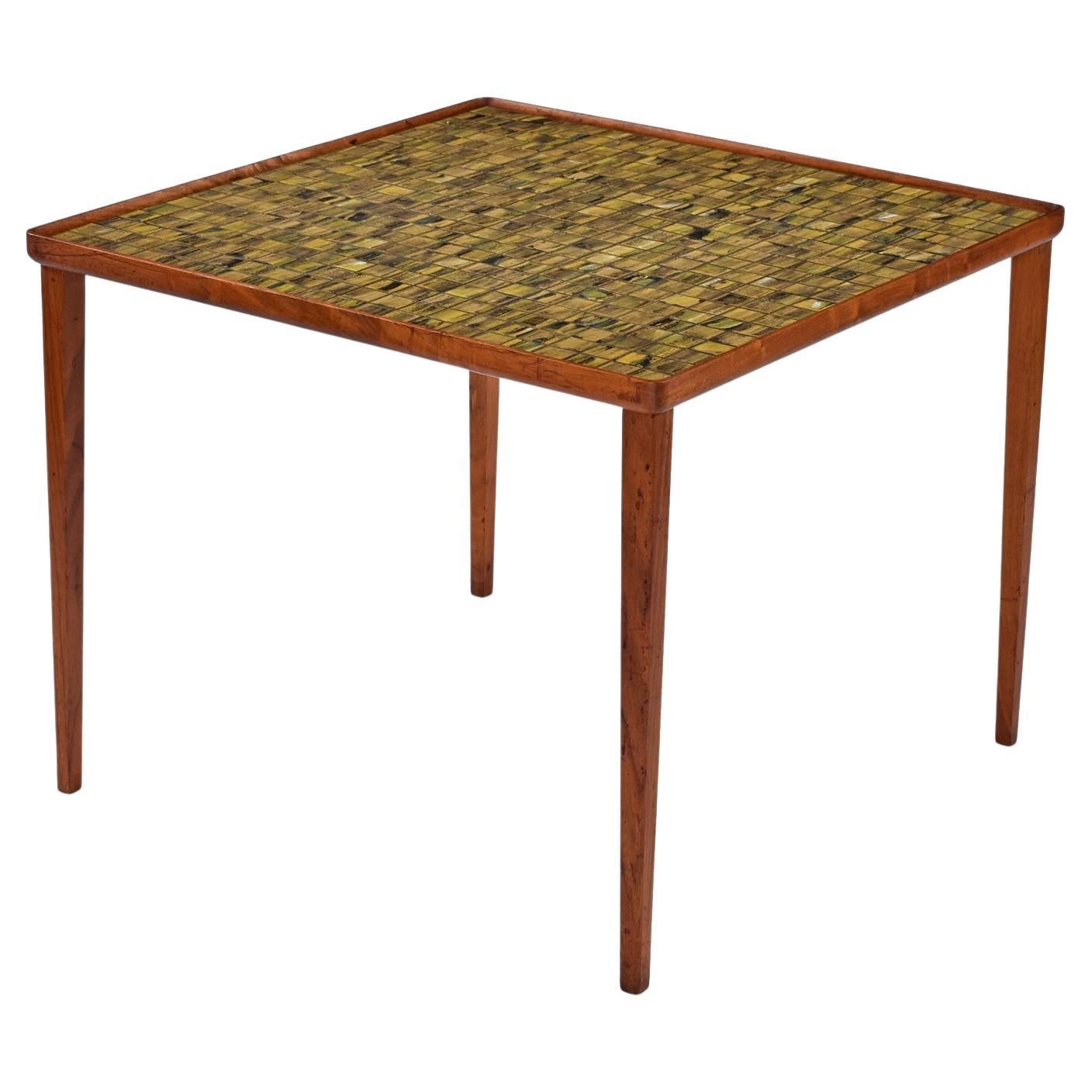 We’ve never seen a tile top Danish teak cocktail table with this captivating tile design.  Each tile is a completely unique, individual work of art.  The tile colors are an ebb and flow of yellows, greens and blacks.  The rich earth tones of the