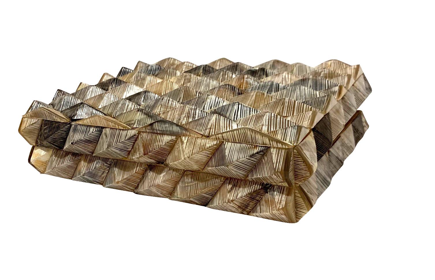 Contemporary Indian lidded bone box with intricate raised geometric pyramid design.
Added texture by etching the bone pieces.
Black, ivory and tan.
Wood lined interior.
Part of a large collection of bone boxes.
