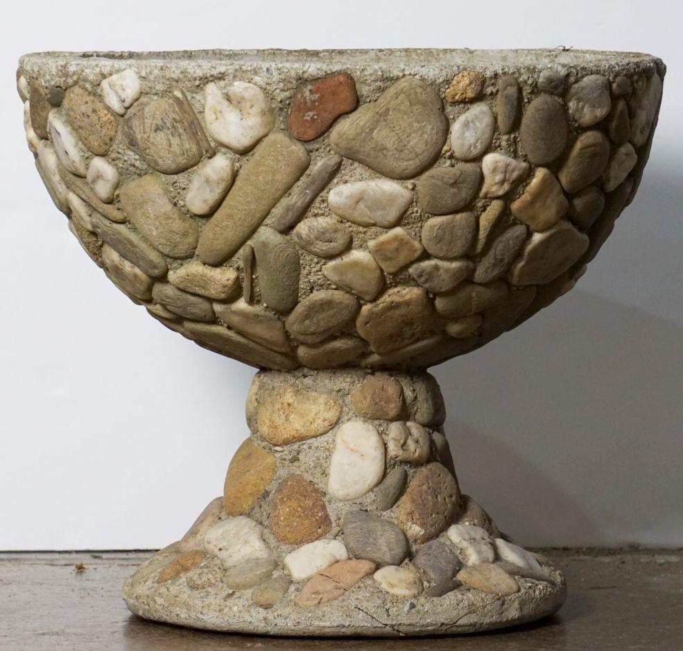 Un pot ou une urne en pierre de jardin français sur un piédestal rond surélevé ou un socle, parfois connu sous le nom de 