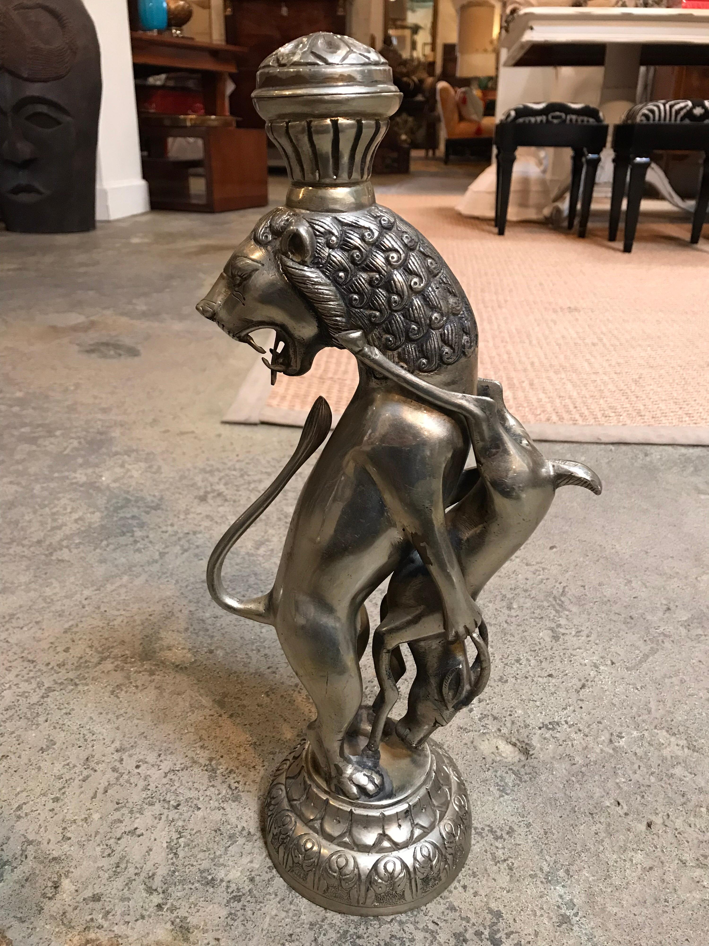 This pair of metallic figurines are cast silver and iron and are very detailed and distinguished. The lion is standing up roaring behind him holding an upside down deer facing towards the lion.