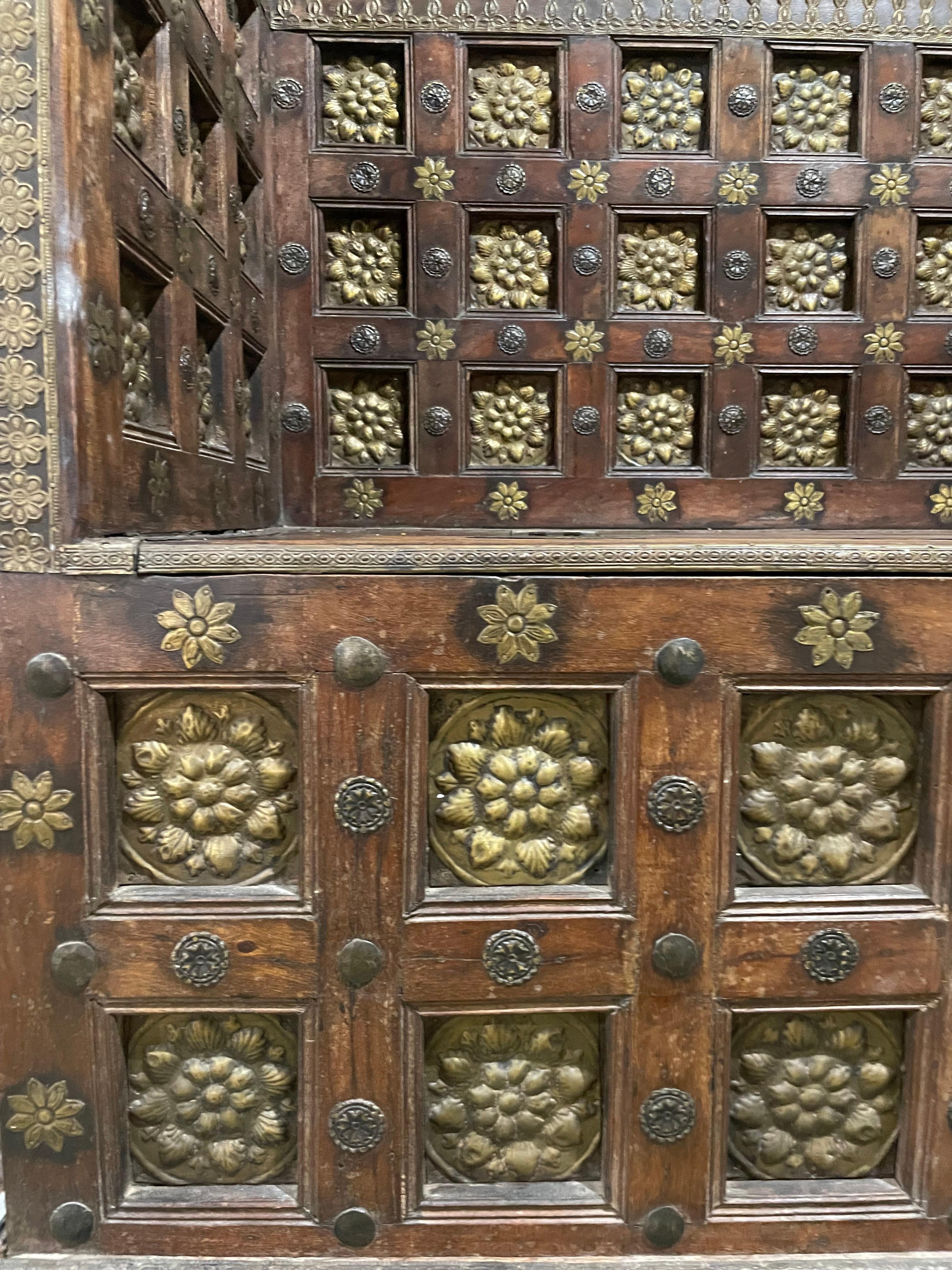 19th century Rajasthani wooden bench chest, carved and partitioned decorated with bronze rosette, opening the chest on the seat of the bench.