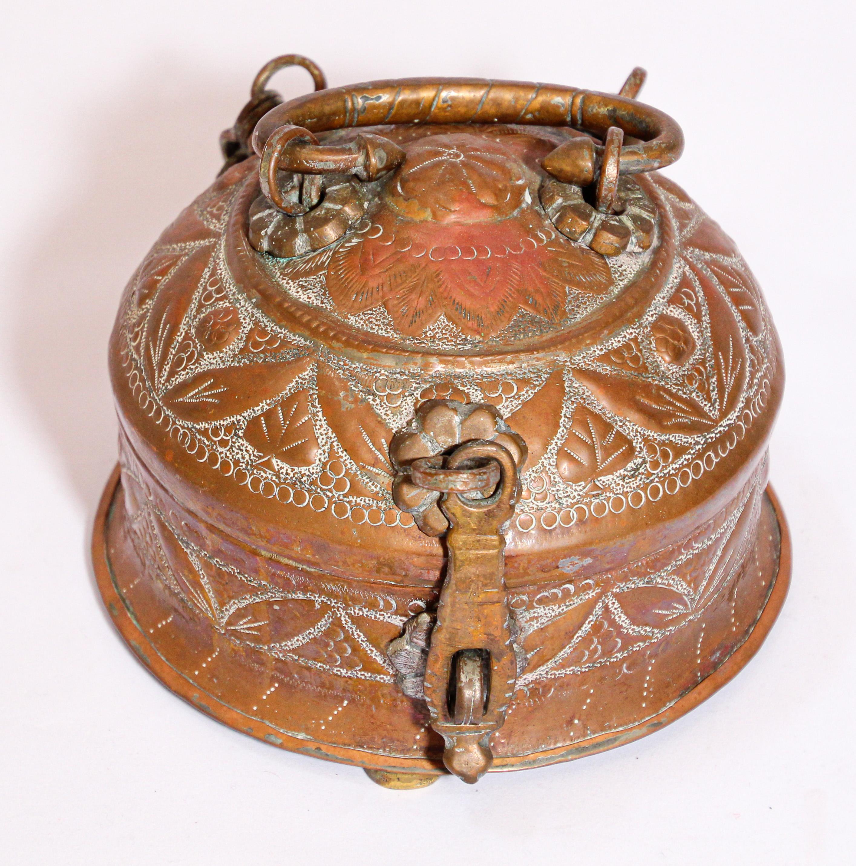 Handcrafted decorative round brass Indian lidded betel box with latch and a top handle.
Delicately and intricately hand-chased with geometric designs.
Used as a tea caddy with tea boxes and tray and cup inside.
Consuming betel leaves with several