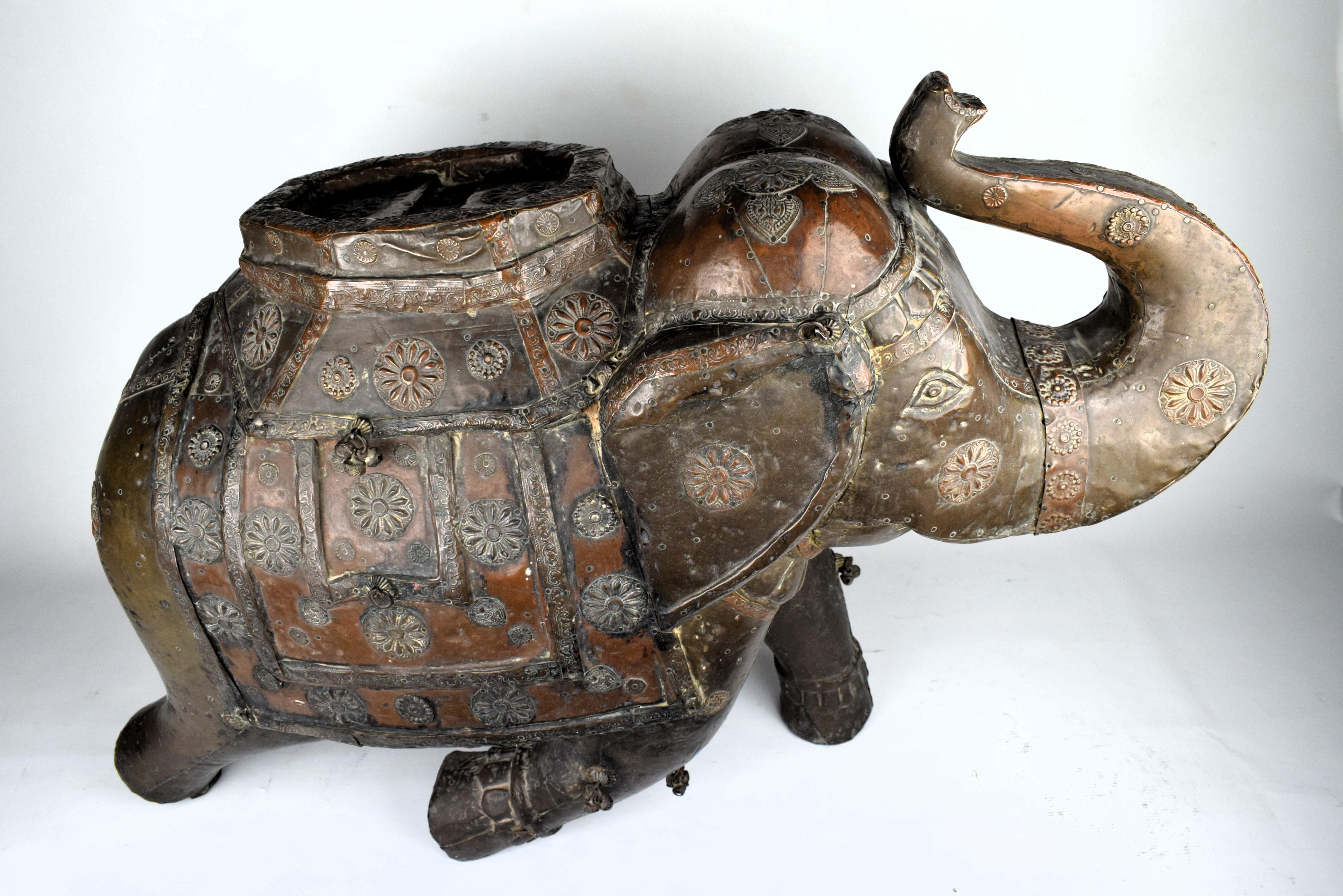 Esta obra maestra de madera intrincadamente tallada se erige como símbolo tanto de excelencia artística como de riqueza cultural. El elefante, una criatura venerada en la tradición india, está adornado con un resplandeciente revestimiento de láminas