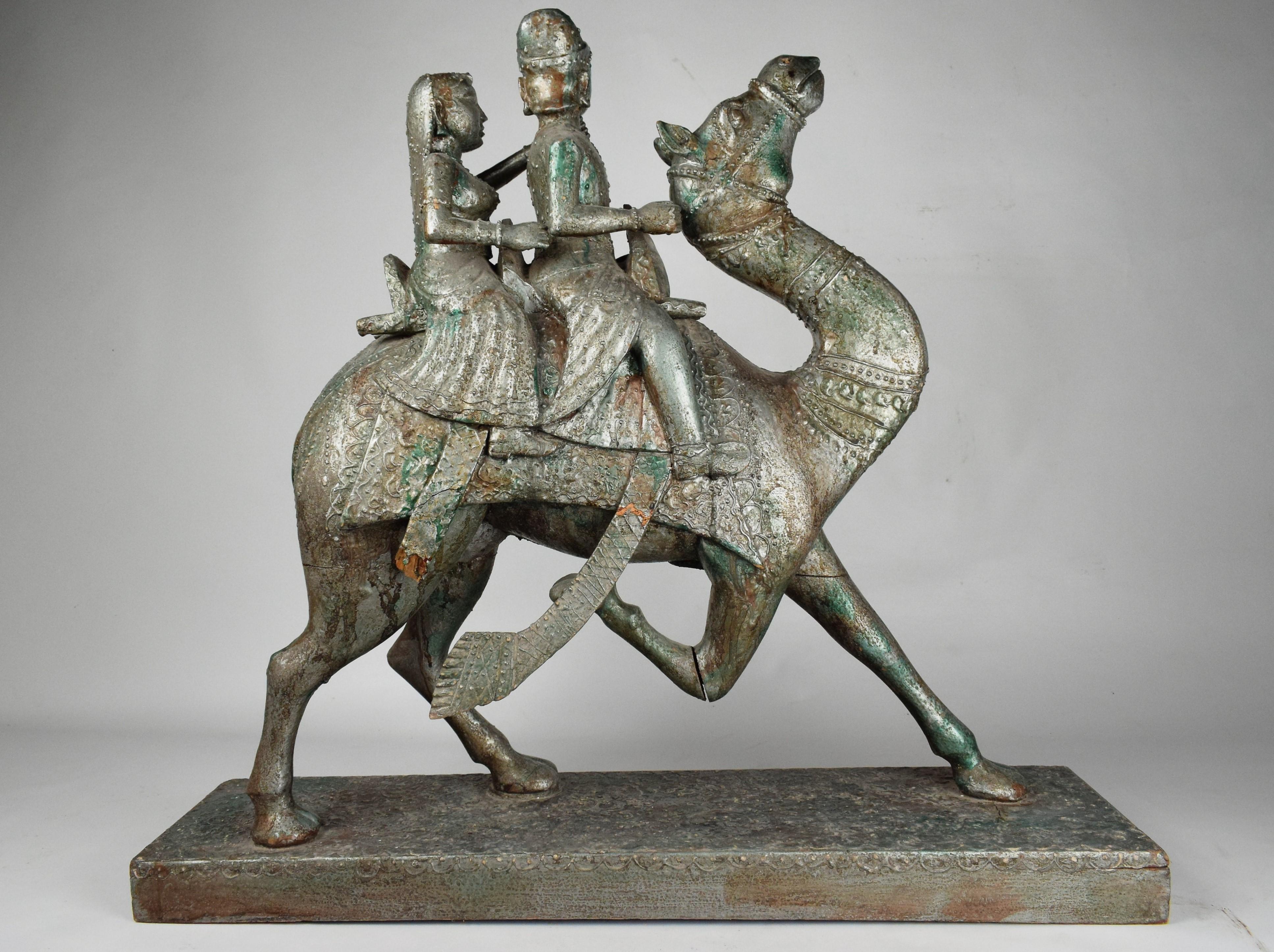 
The beautifully crafted wooden sculpture depicting an Islamic Rajasthani couple riding a majestic camel. The wooden figures are intricately carved with attention to detail, capturing the essence of traditional Rajasthani attire and Islamic cultural