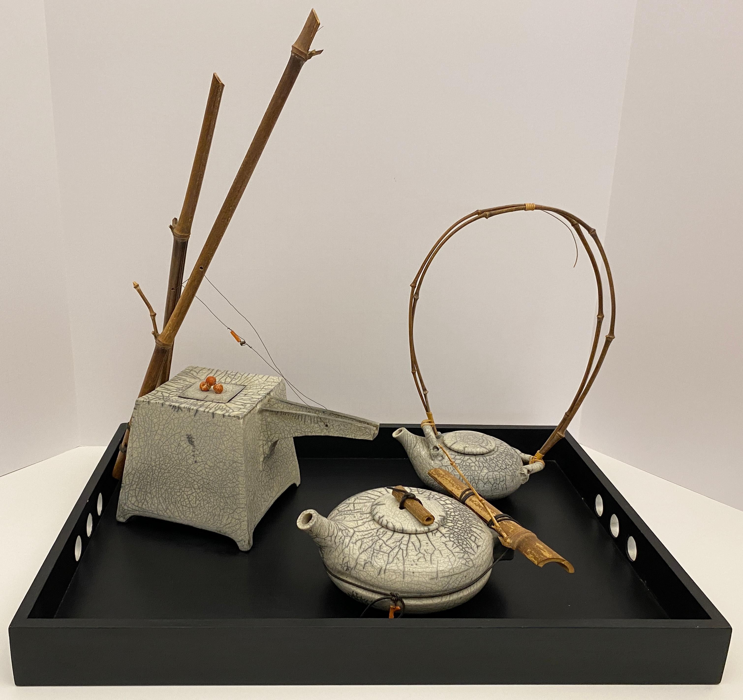 Set artigianale di tre oggetti decorativi in ceramica bianca con vassoio. 
Questi pezzi di ottima qualità sono stati creati seguendo l'antica tecnica giapponese del Raku con un elegante effetto crepato.  Firmato. 

Questo set di ceramica in stile