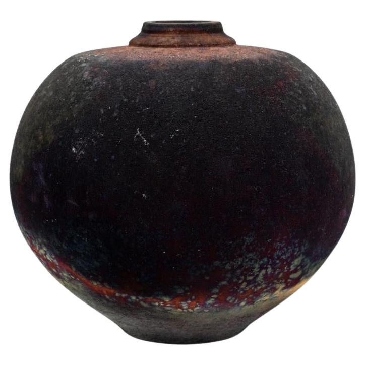 Bob Green Southern Folk Art Burnished Raku Vessel
This stunning burnished raku ceramic vessel by Bob Green, a celebrated Southern folk artist, showcases the captivating unpredictability of the raku firing technique. The process involves removing the