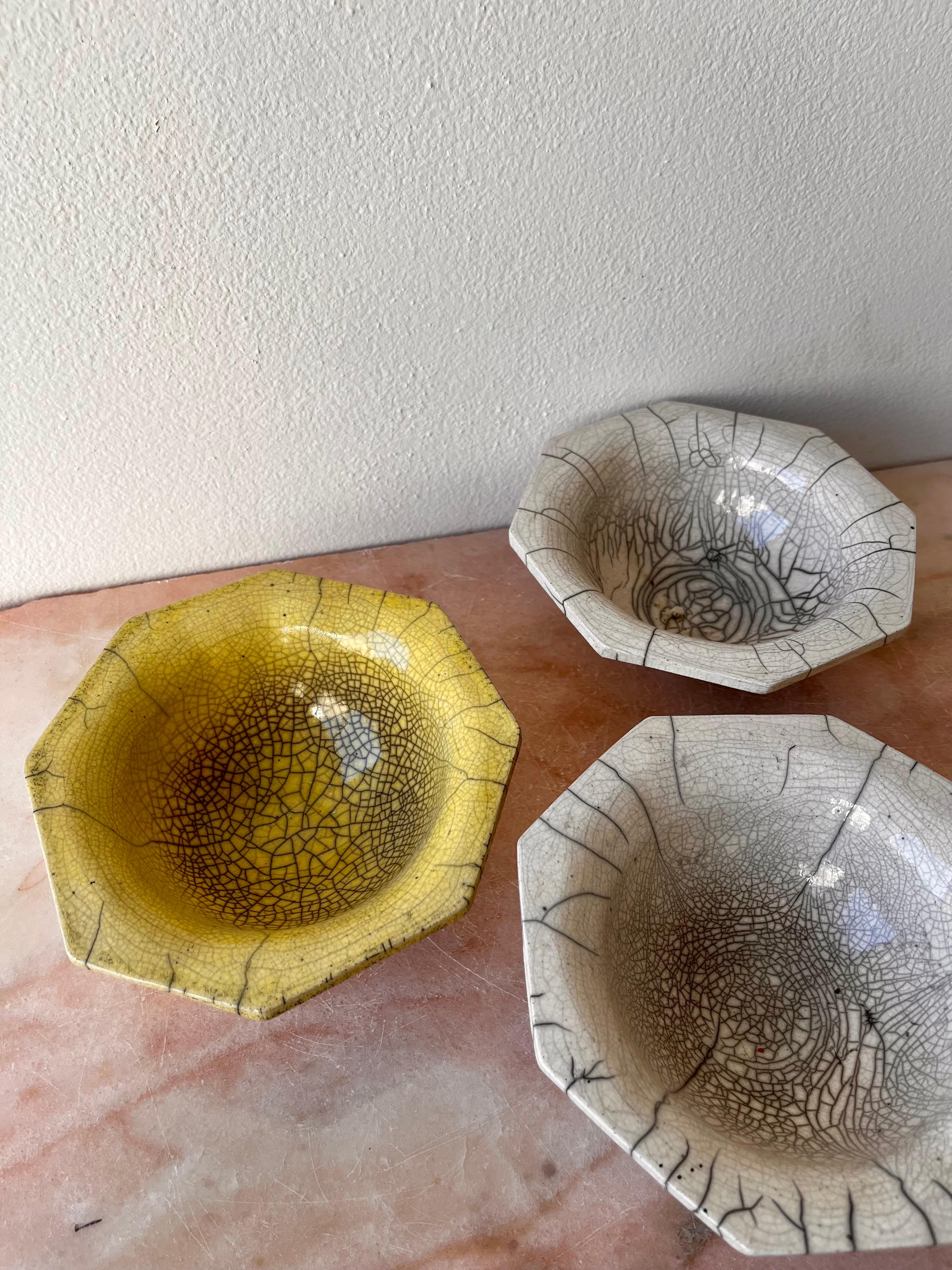 Decorative bowls fired in the traditional Japanese Raku method, with yellow or white smoke-stained crackle glaze.

Octagonal or square rim. Not food-safe.