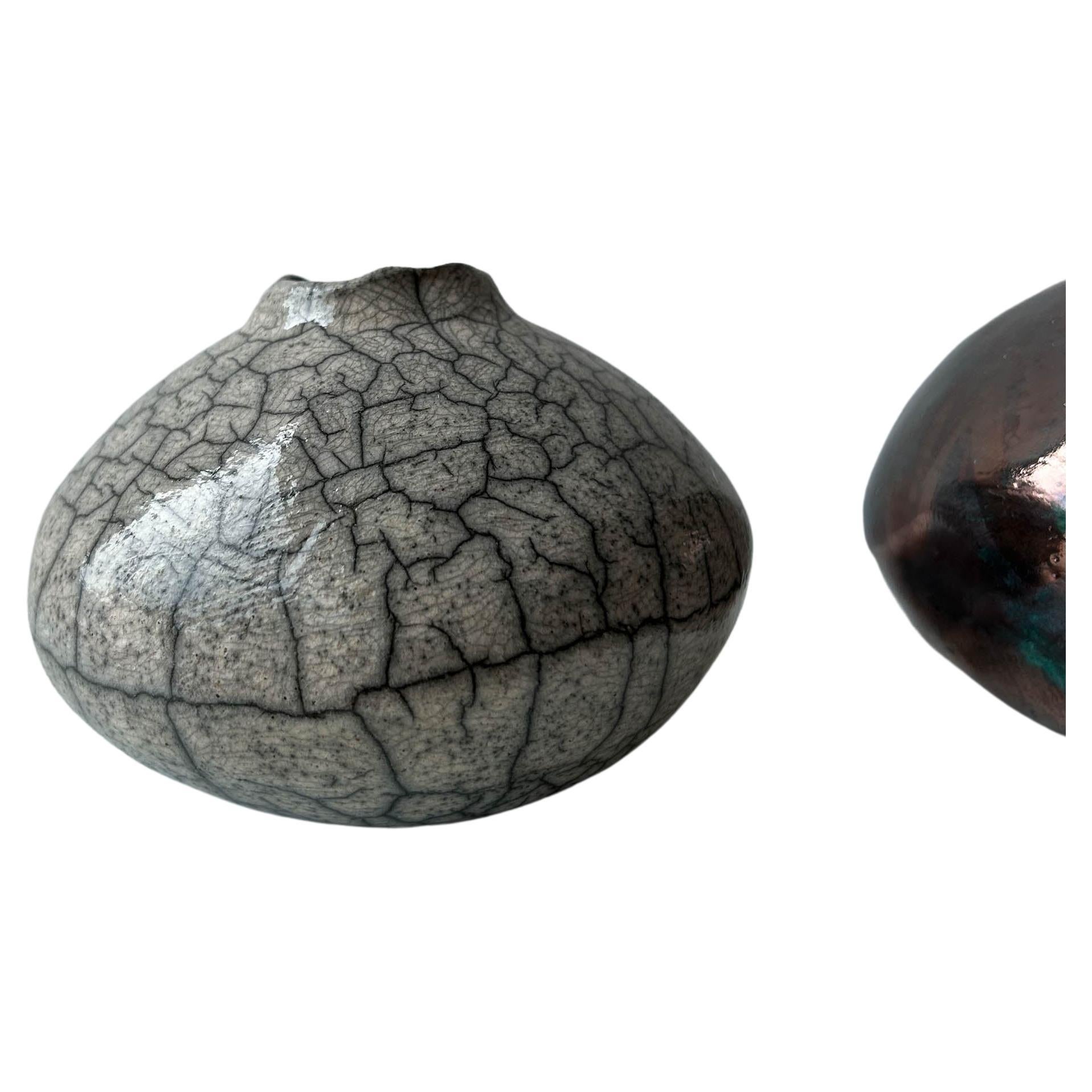 One-of-a-kind raku-fired vase. Clear crackle glaze over stoneware on an imperfectly round form. Part of a series, each is one of a kind. 

Made in our Brooklyn studio then fired in a New Jersey back yard,

All dimensions are approximate as each