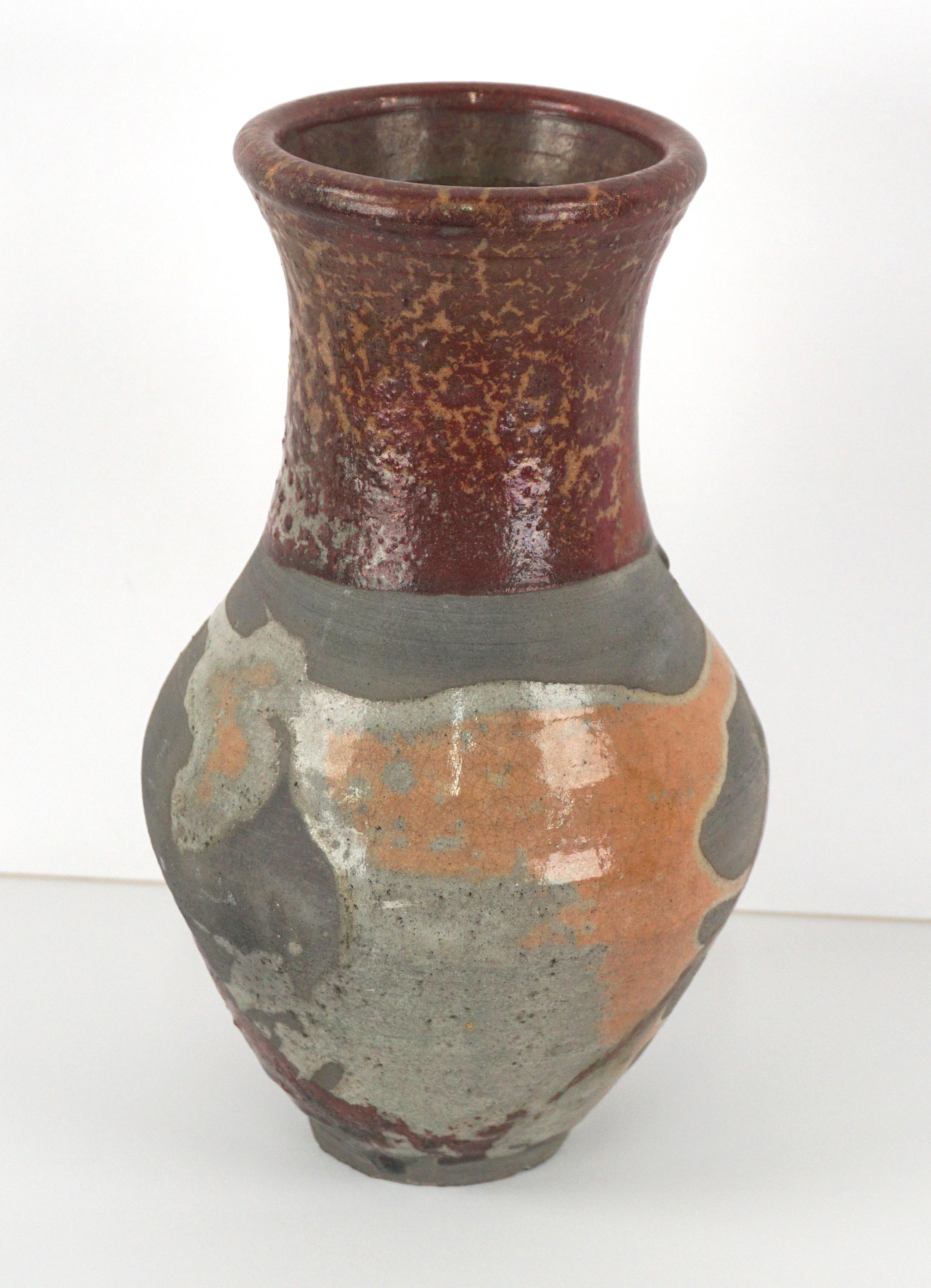 Dramatic raku style ceramic vase by ceramic artist Andy Ruble (American, b 1970). Metallic russet, grays and orange lend to earthy organic aesthetic. Signed on bottom. Size: 9.25