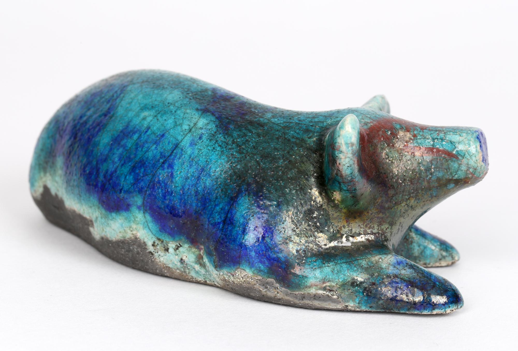 Delightful studio pottery raku glazed figure of a resting pig dating from the 20th century. The hollow hand-crafted ceramic pig is simply detailed in a lying position with its head raised and is nicely potted Pottery and decorated in turquoise, blue