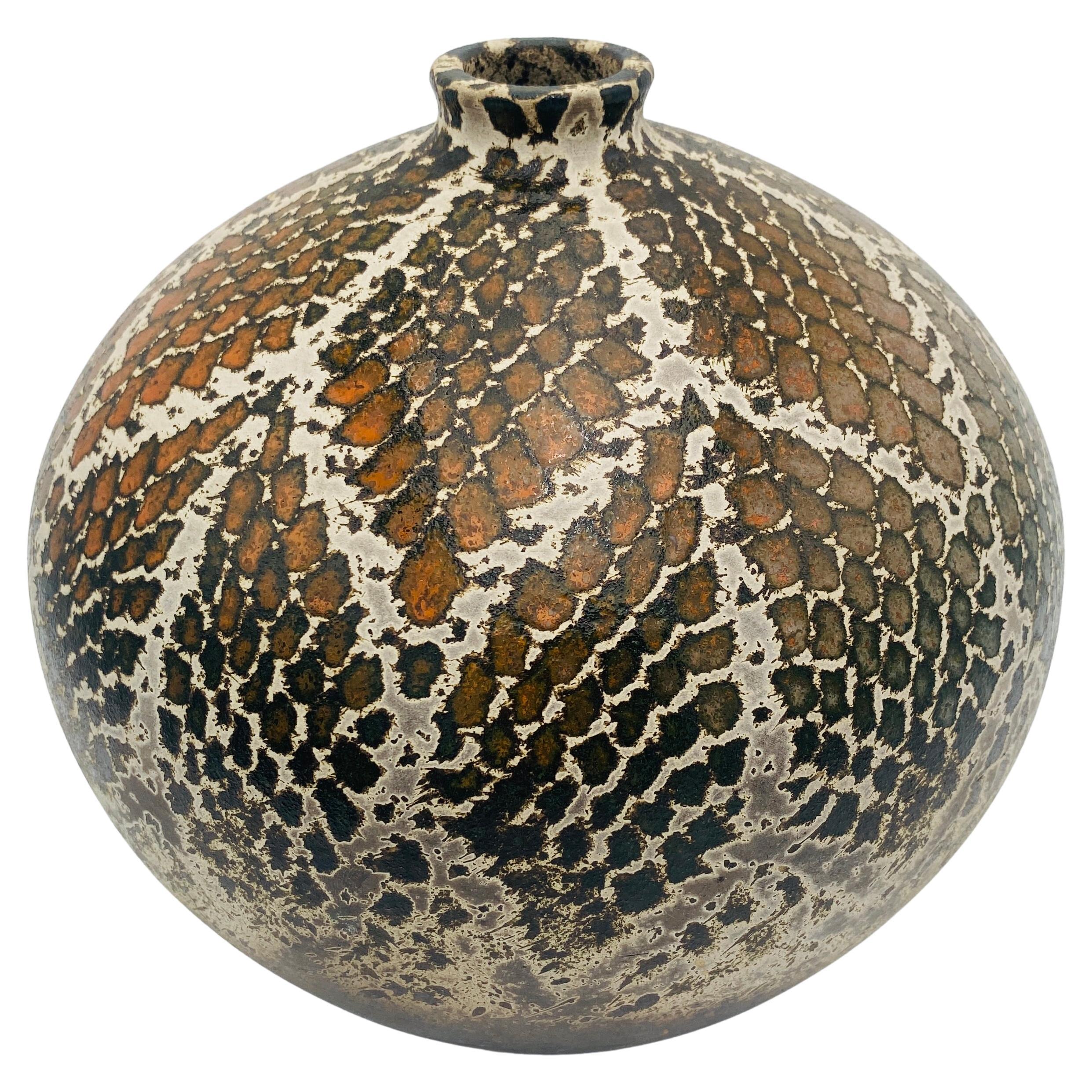This is a snakeskin pattern raku vase made by James Franklin in Santa Fe, New Mexico. The handmade pottery is signed 