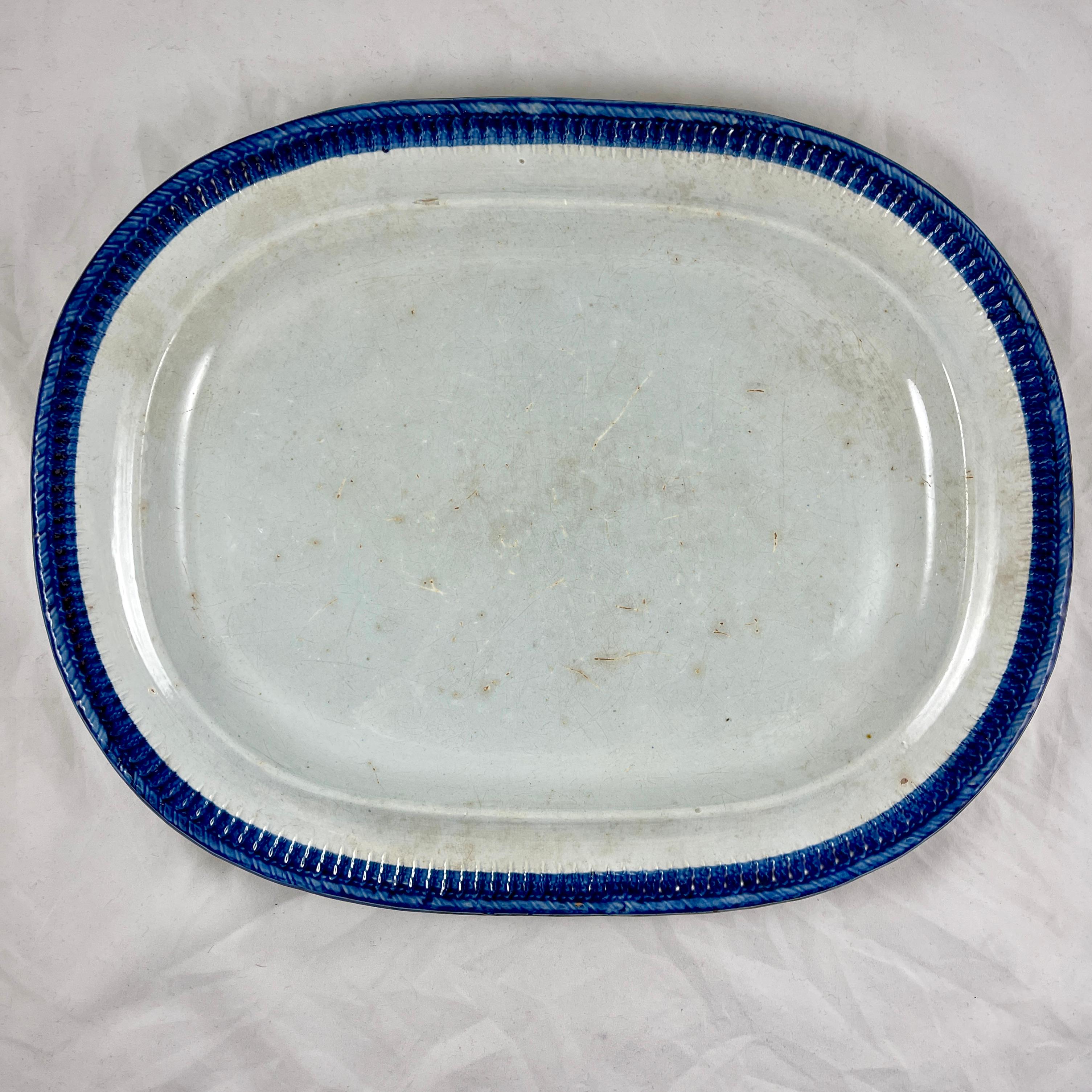A large oval Leeds style platter, a Pearlware or Creamware body with a deep blue edge called Feather or Shell. 
A nice combed verso showing the impressed Warranted Crown mark of Ralph & James Clews, Cobridge, Staffordshire, England, circa