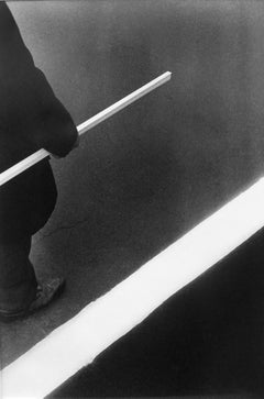 Homme, bâton, bande blanche - Photographie noir et blanc, graphique, minimal