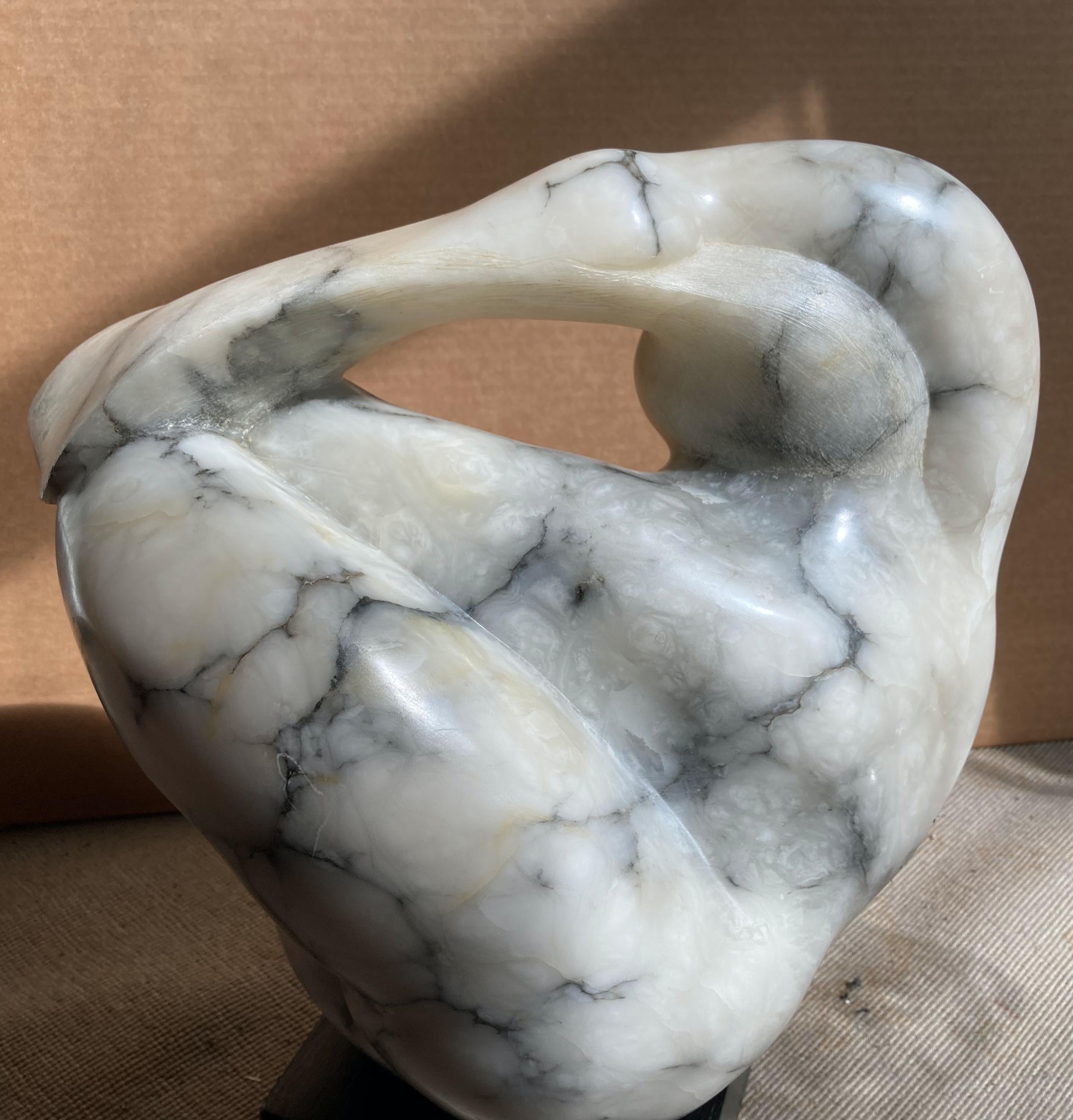 This gorgeous marble sculpture falls in that magic area between abstraction and representation. It loosely depicts a woman combing her hair, but really is about the beautiful curves and lines. Stunning veined alabaster. A substantial sculpture,