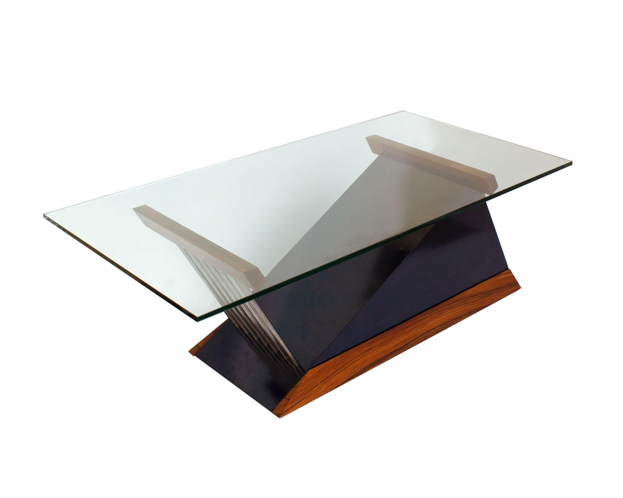 A 1986 Modernist coffee table designed by the American furniture designer Ralph K. Rye (born 1925). The table has a rectangular glass top that rests on a metal, black laminate, and wooden base. Shaped like in the form a triangle, the black laminate