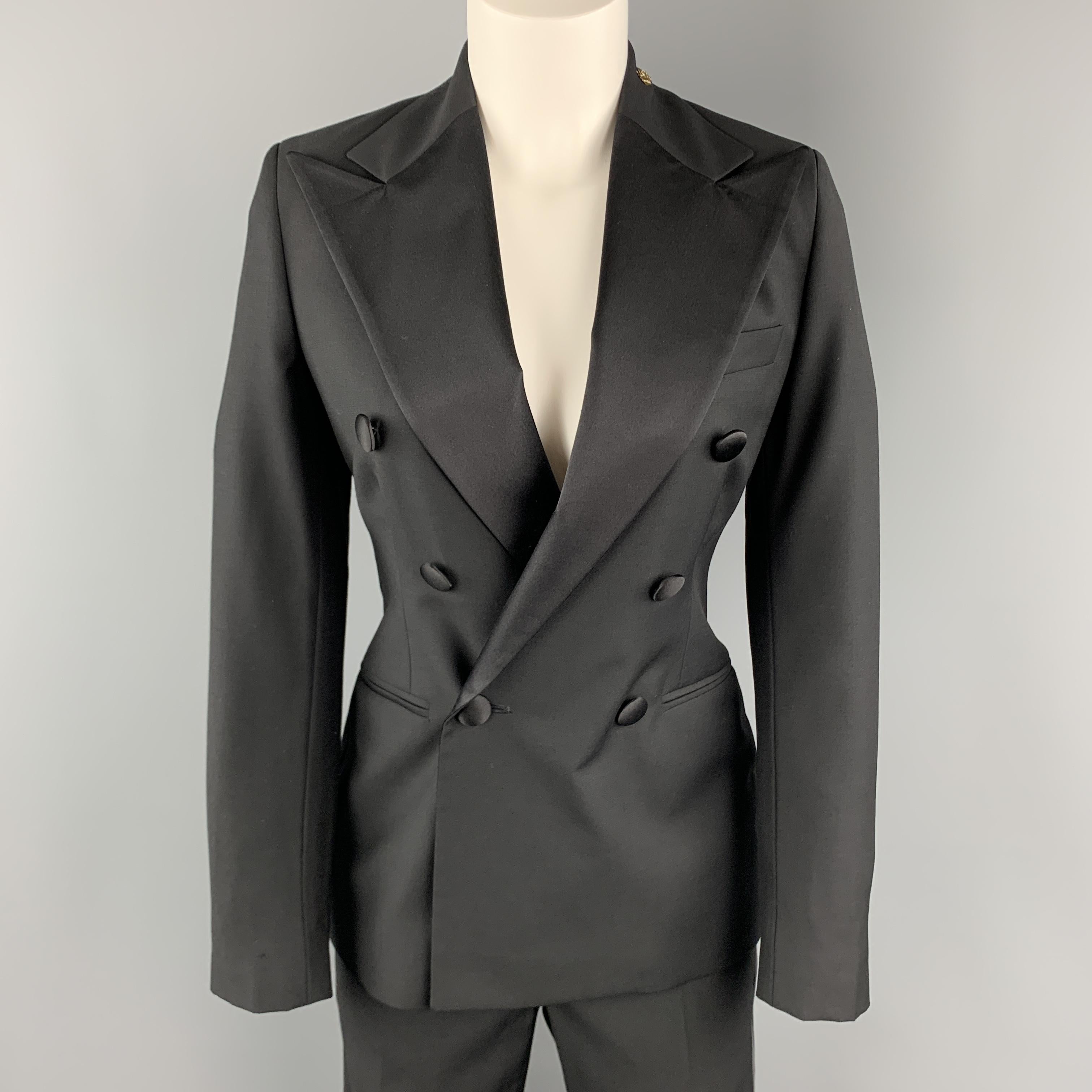 RALPH LAUREN BLUE LABEL tuxedo suit comes in black wool gabardine and includes a double breasted sport coat with satin peak lapel detailed with a skull brooch and matching flat front satin stripe trousers. Made in The USA.

Excellent Pre-Owned