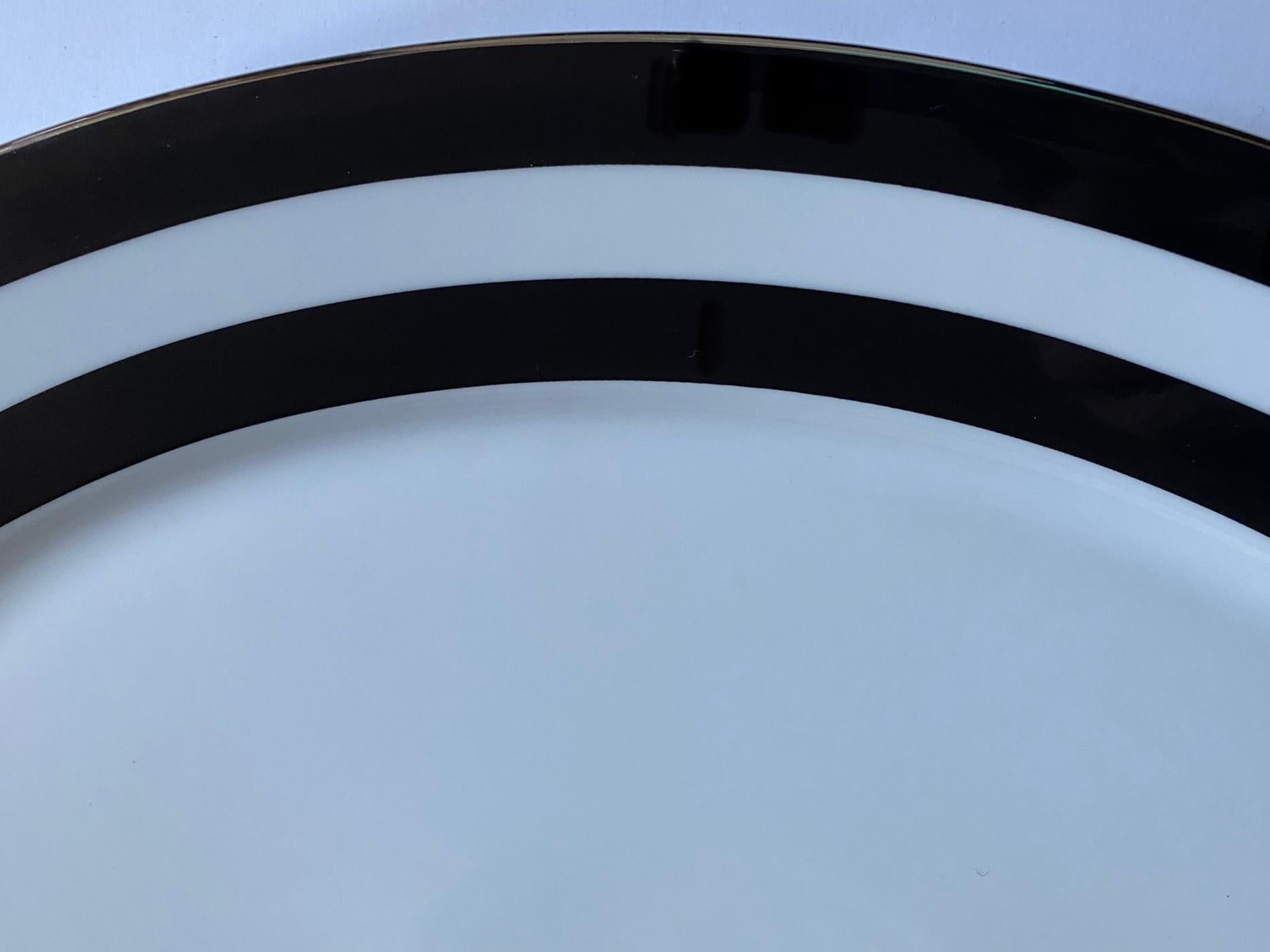 Eine ovale Servierplatte mit dem Muster Spectator Black der Collection'S von Ralph Lauren Home. Knochenporzellan. Unterschrieben. Importiert, Produktionszeitraum 1995-2002.

Ein breiter schwarzer Doppelstreifen wird durch eine