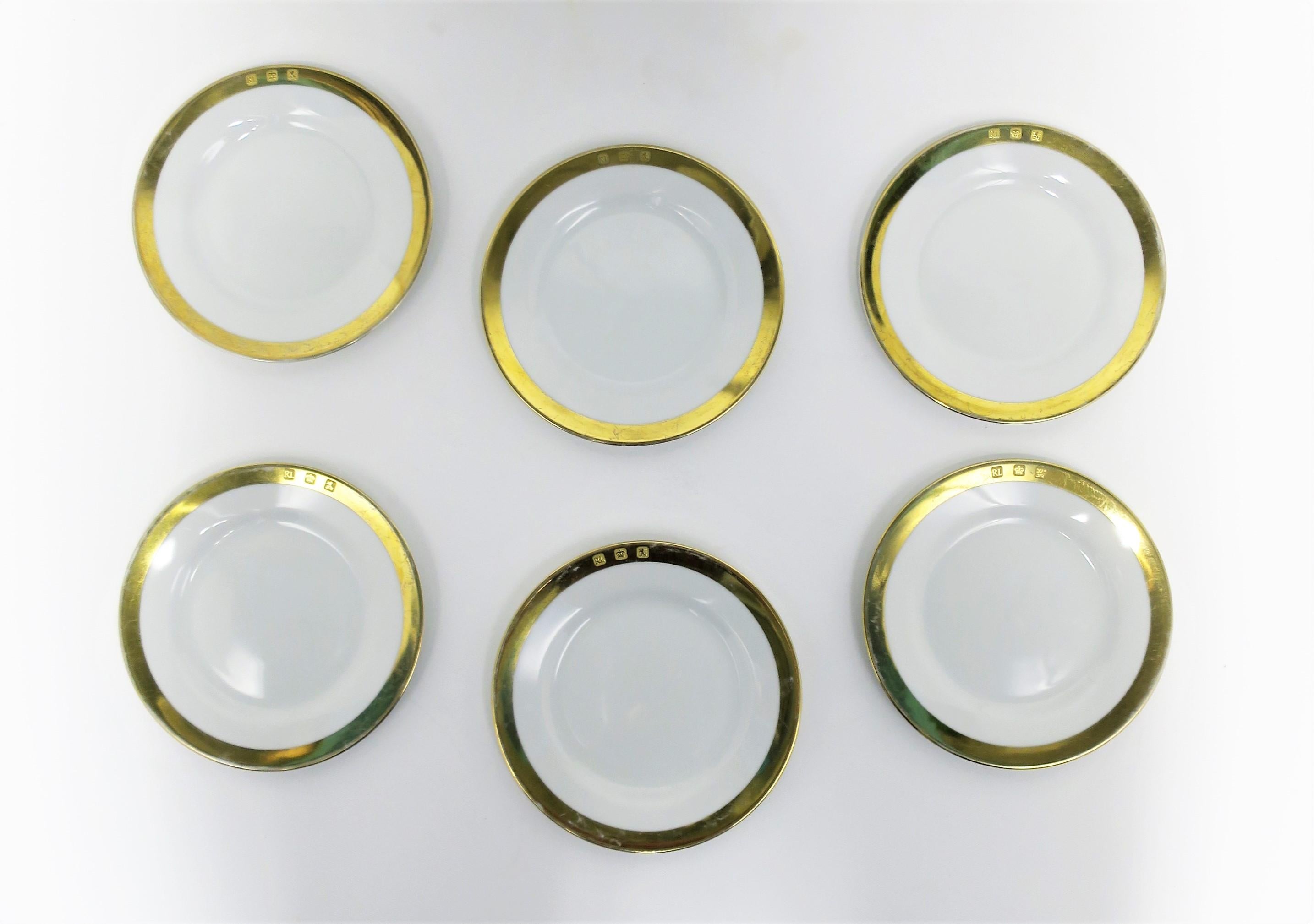 A 1990s vintage set of six (6) appetizer or bread and butter white porcelain plates with gold detail from American fasion design house Ralph Lauren, 1995. Plates in the 