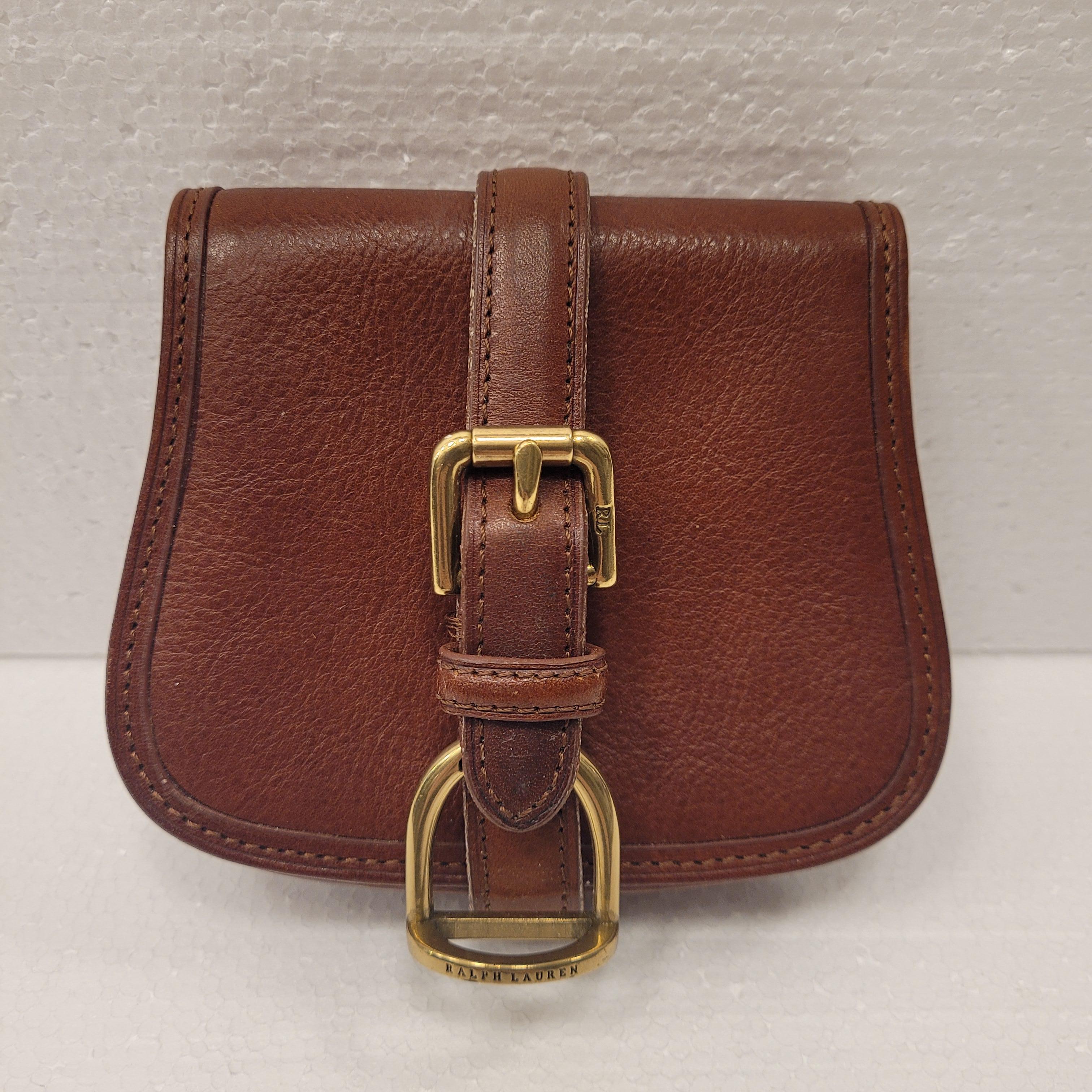 Precioso y elegante bolso cinturón o monedero pequeño de piel marrón de Ralph Lauren. Logotipo en relieve en el interior de la solapa y en los herrajes. Se puede colocar en el cinturón. Una bolsa ideal para cualquier evento especial e incluso para