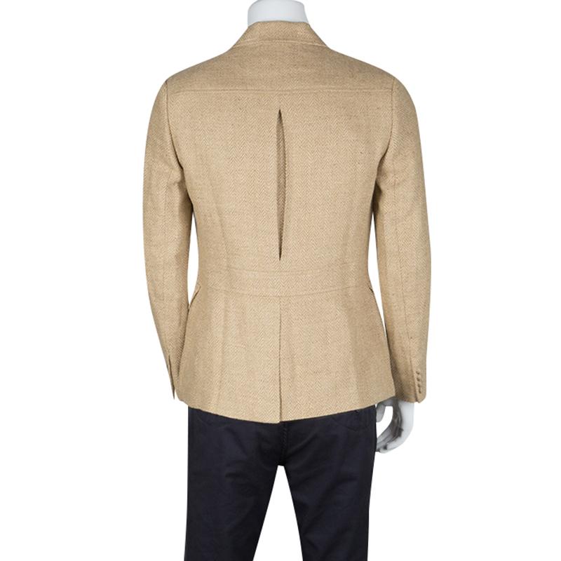 Tailored from a beige linen fabric, this blazer from Ralph Lauren is designed with the iconic Herringbone weave pattern on it. The single-breasted style comes with a spread collar, patch waist pockets and a chest pocket and detailed with a pleated