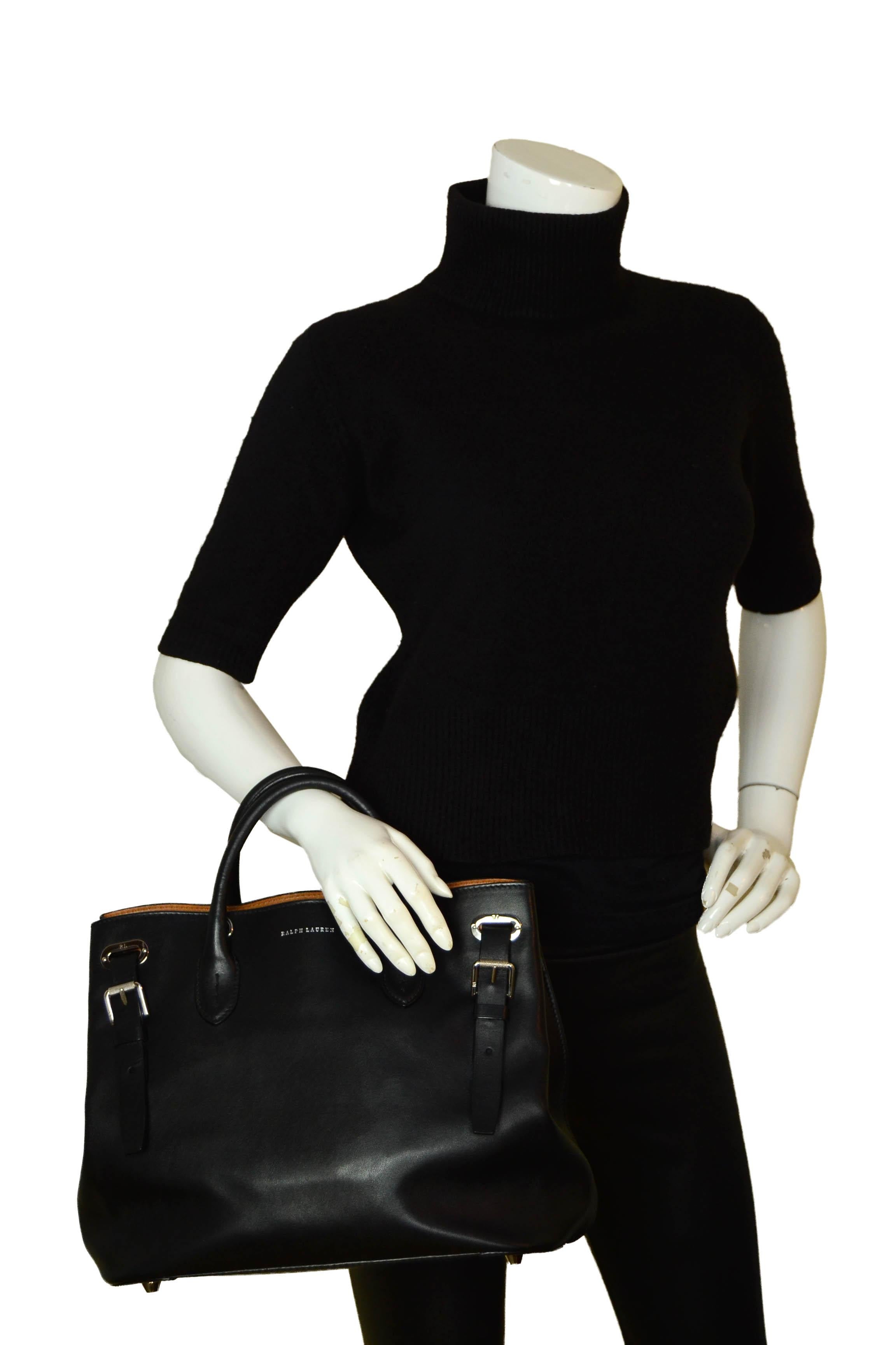 Ralph Lauren Black Leather Buckle Tote Bag W/Strap

Made In: Italy
Color: Black
Hardware: Silvertone
Materials: Leather
Lining: Textile & leather trim
Closure/Opening: Open top
Interior Pockets: middle zipper, phone wall pocket, slit wall pocket