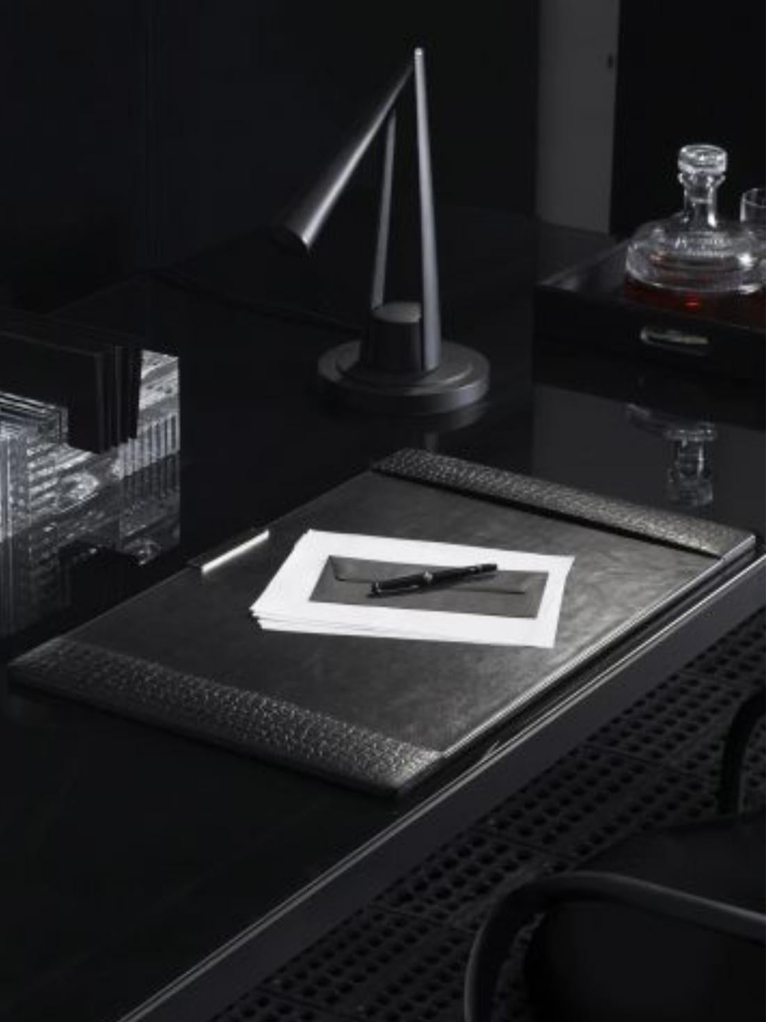 This Ralph Lauren black printed crocodile embossed leather desk blotter is a clean and modern desk accessorie inspired by Ralph Lauren timeless leather accessories. The blotter has a metal chrome detail. 
Writing on it is a pleasant