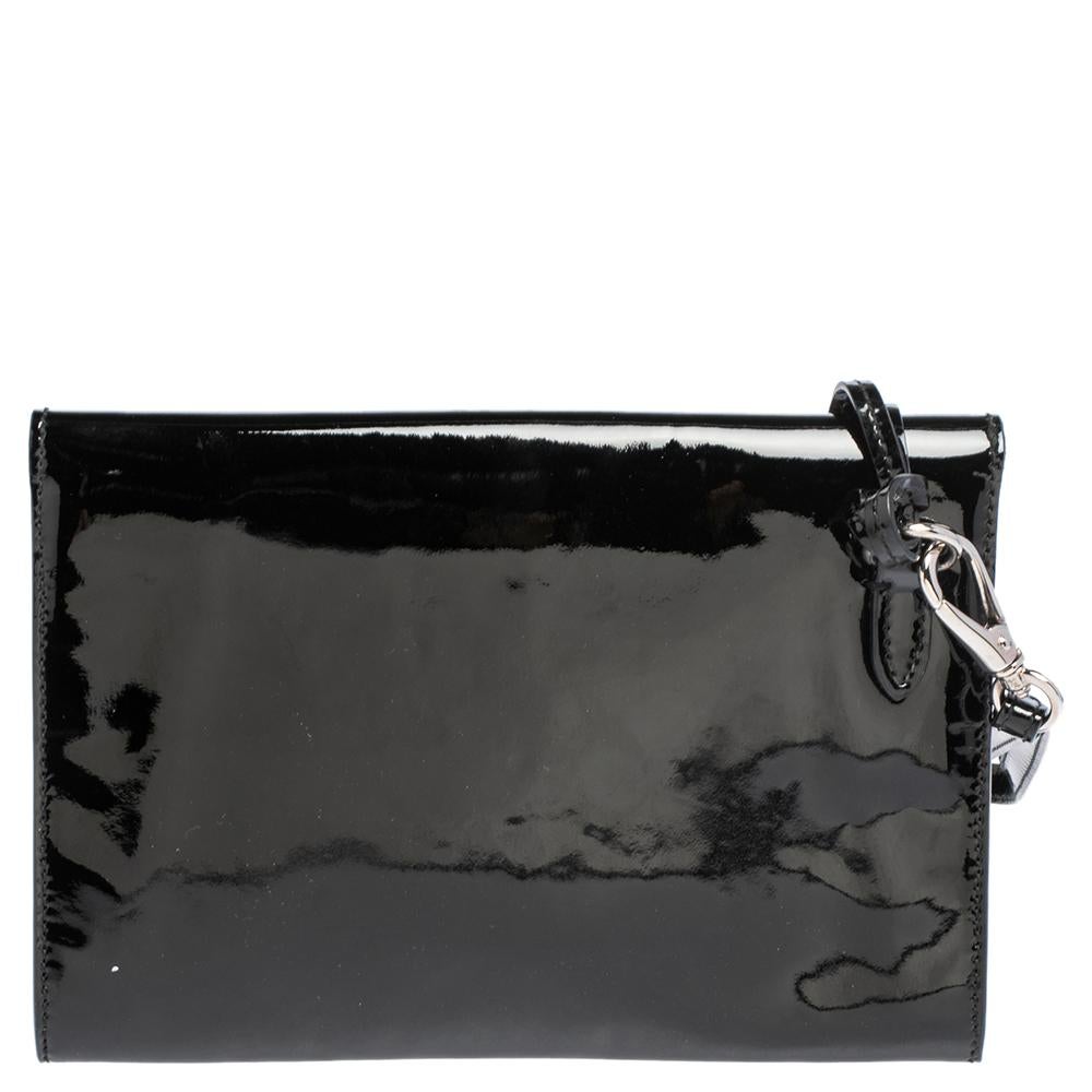 This Ralph Lauren Ricky clutch is simply breathtaking. Meticulously crafted from patent leather, the bag delights not only with its appeal but its structure as well. It comes in black color and features a front flap with a silver-tone closure that