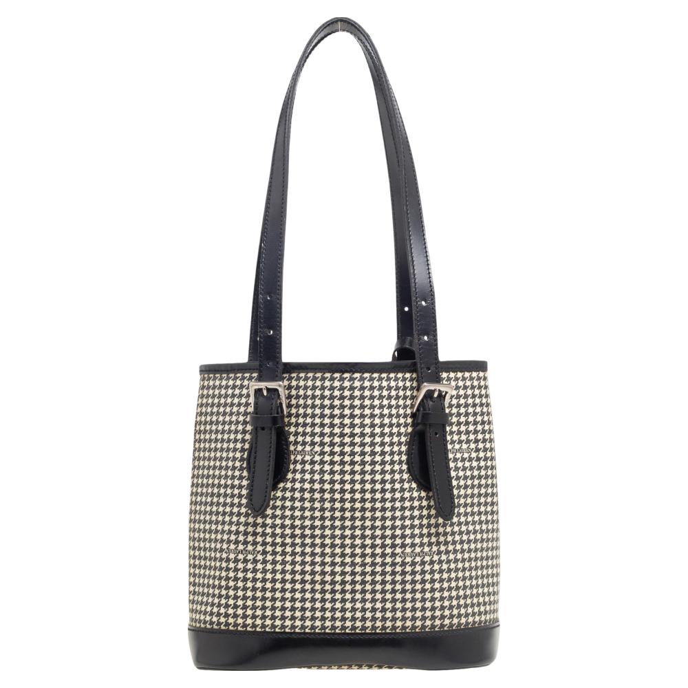 This Houndstooth tote from Ralph Lauren is made to offer style and elegance. It is made from black-white canvas and leather on the exterior and displays dual handles, silver-toned hardware, and a canvas-lined interior. This tote is great for