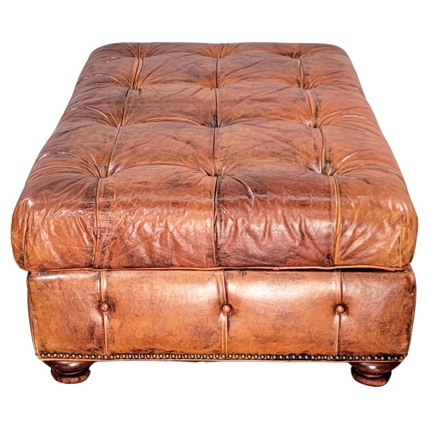 Luxurious Ralph Lauren button tufted leather storage ottoman with nailhead trim and turned mahogany wood legs. The large Chesterfield ottoman, which can also be used as a coffee table, is covered in a gorgeous Ralph Lauren distressed brown leather