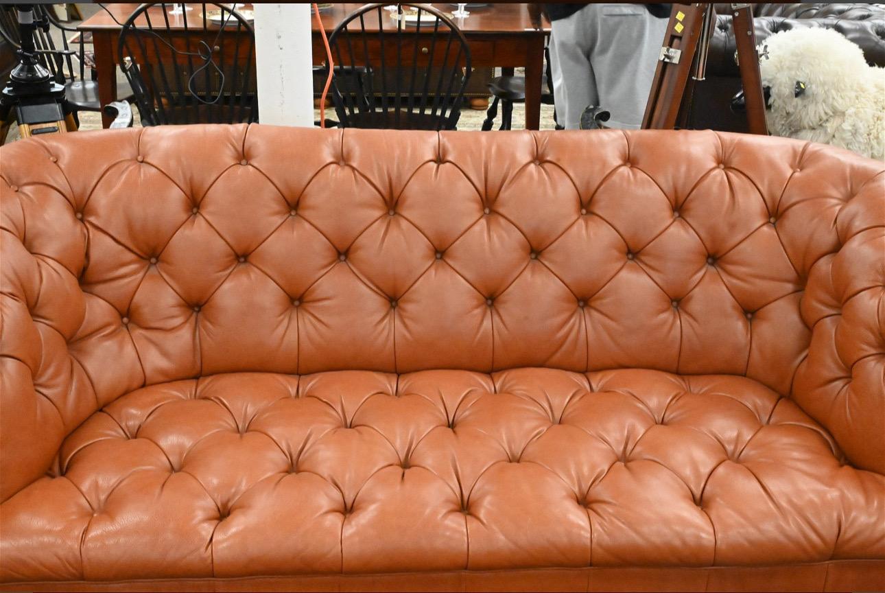 Precioso Sofá Chesterfield Vintage con profundos mechones de botones, brazos enrollados y ruedas de latón. Acabado en cuero coñac. Sin firmar, se cree que es Ralph Lauren. 